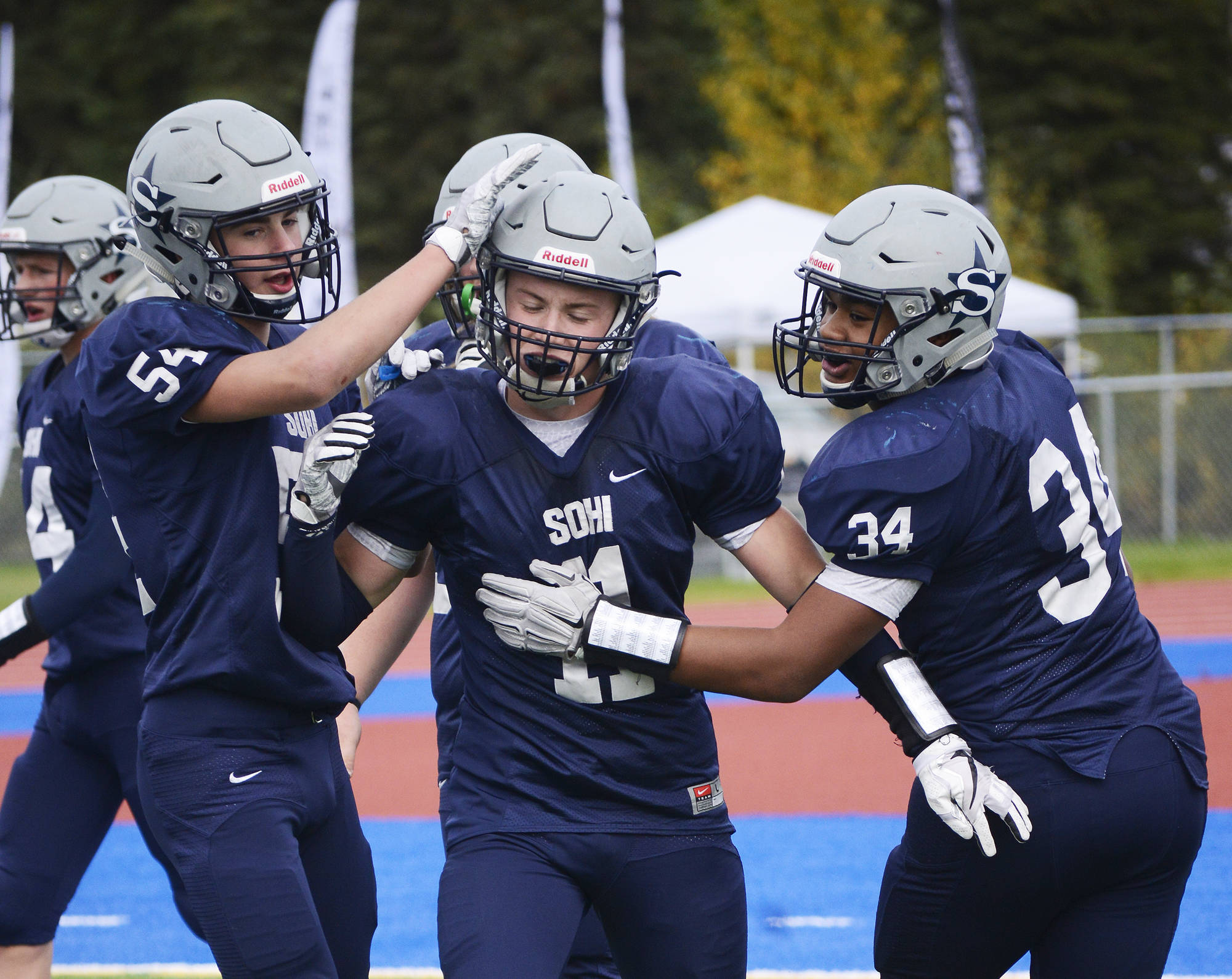 Soldotna running back Brenner Furlong (center) receives congratulations from teammates Zach Hanson (left) and Aaron Faletoi (right) after scoring a touchdown Sept. 16 at Justin Maile Field in Soldotna. (Photo by Joey Klecka/Peninsula Clarion)