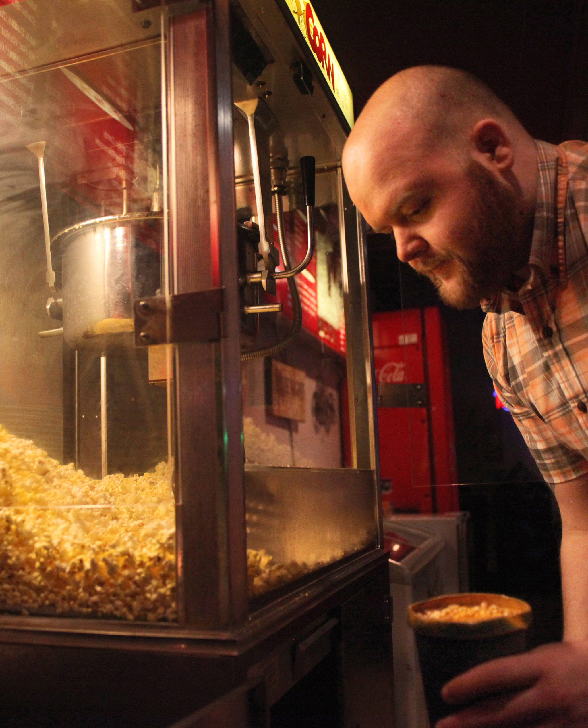 Orca Theatre manager Jordan Gruber makes popcorn for the next rush of movie-goers on Monday, Dec. 25, 2017 at the Orca Theatre on Kalifornsky Beach Road near Kenai, Alaska. (Photo by Ben Boettger/Peninsula Clarion)