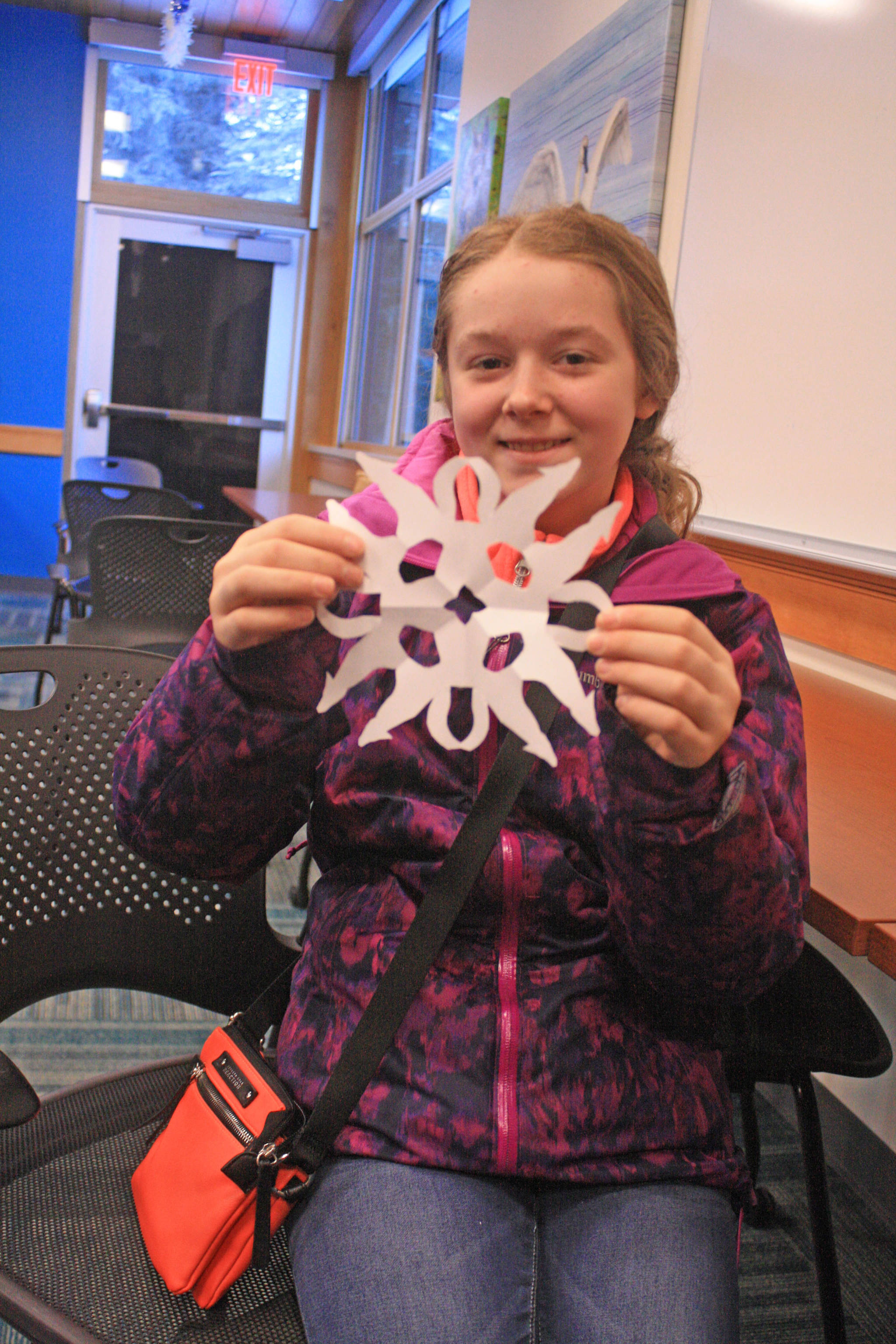 Audrey Larson, 13, shows off the paper snowflake she crafted while attending a family fun day at the Kenai National Wildlife Refuge Visitor Center on Dec. 27. (Photo by Erin Thompson/Peninsula Clarion)