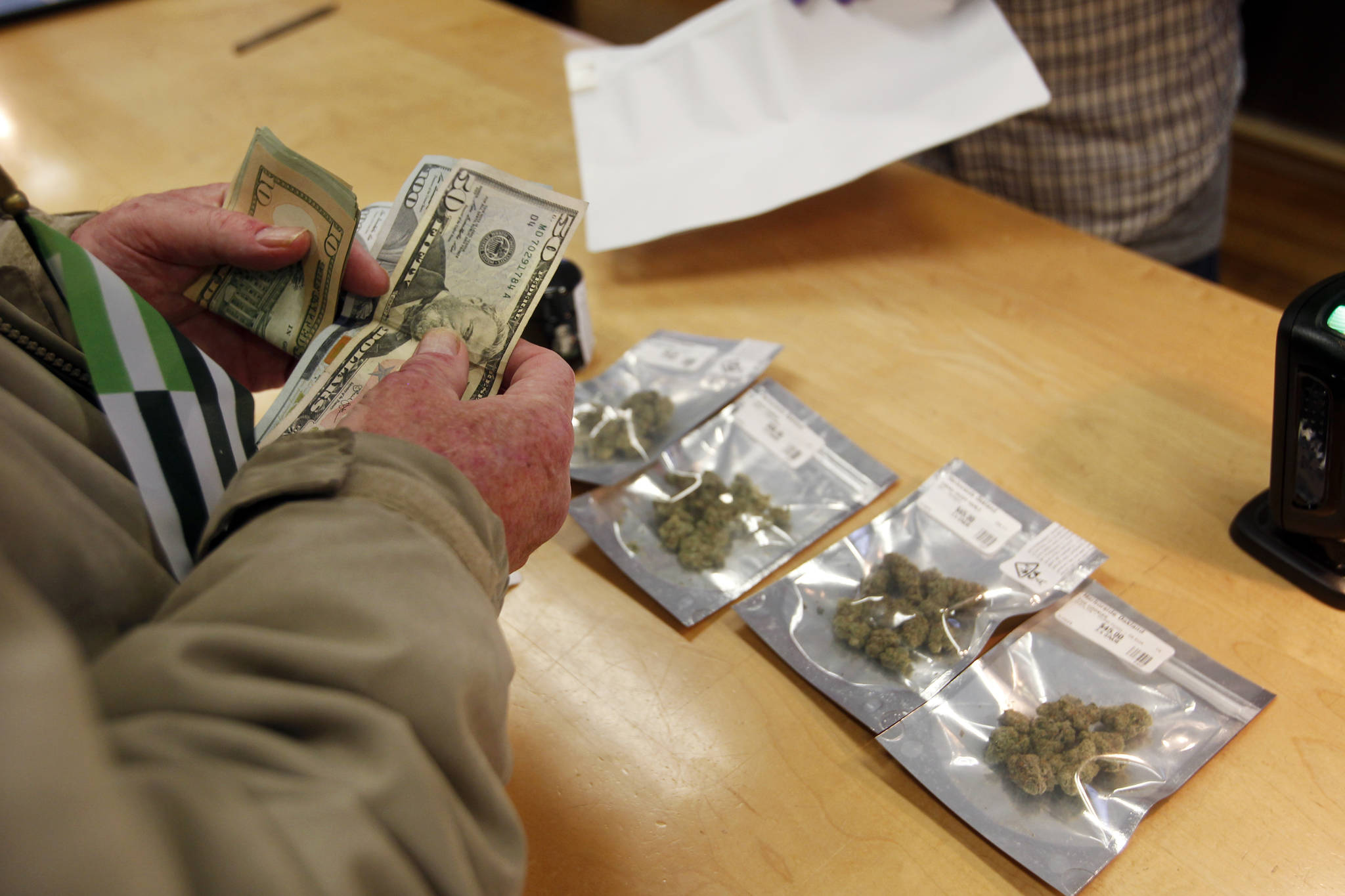In this Jan. 1, 2018 file photo, a customer purchases marijuana at the Harborside marijuana dispensary in Oakland, Calif., on the first day that recreational marijuana was sold legally in California. In January 2018, Attorney General Jeff Sessions rescinded a 2013 Obama Administration policy pledging that federal authorities would not crack down on marijuana operations in states where they were legal as long as the states maintained tight regulations. (AP Photo/Mathew Sumner)