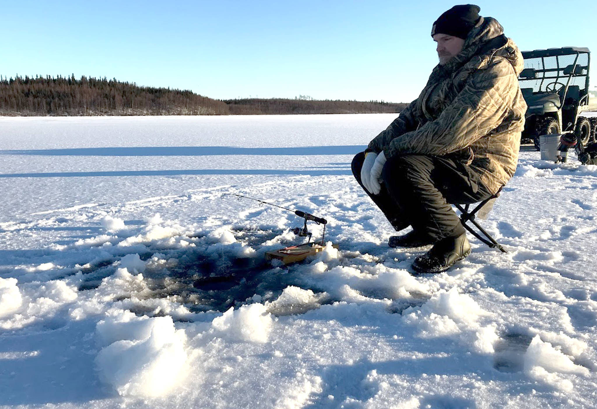 Jon Watson, pastor at Peninsula Christian Center of Soldotna and avid ice fisherman, watches his rod during a day on Spirit Lake on Dec. 26, 2017. (Photo by Kat Sorensen/Peninsula Clarion)