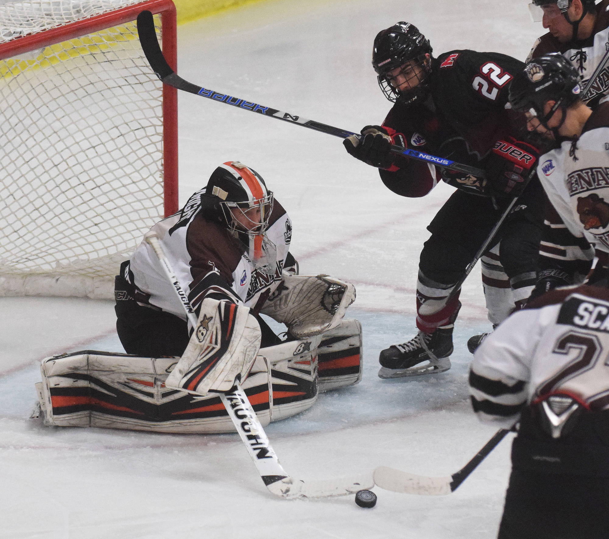 Kenai River Brown Bears goaltender Gavin Enright attempts to reel in the puck ahead of a scrum of players Oct. 27, 2017, against the Minnesota Magicians at the Soldotna Regional Sports Complex. (Photo by Joey Klecka/Peninsula Clarion)