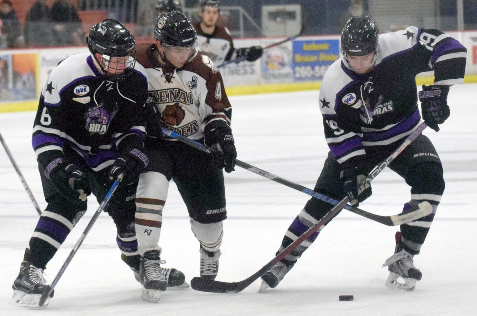 Kenai River’s Sacha Guillemain battles Wyatt Mathews and Ture Linden of the Lone Star (Texas) Brahmas for the puck Friday, Jan. 19, 2018, at the Soldotna Regional Sports Complex. (Photo by Jeff Helminiak/Peninsula Clarion)