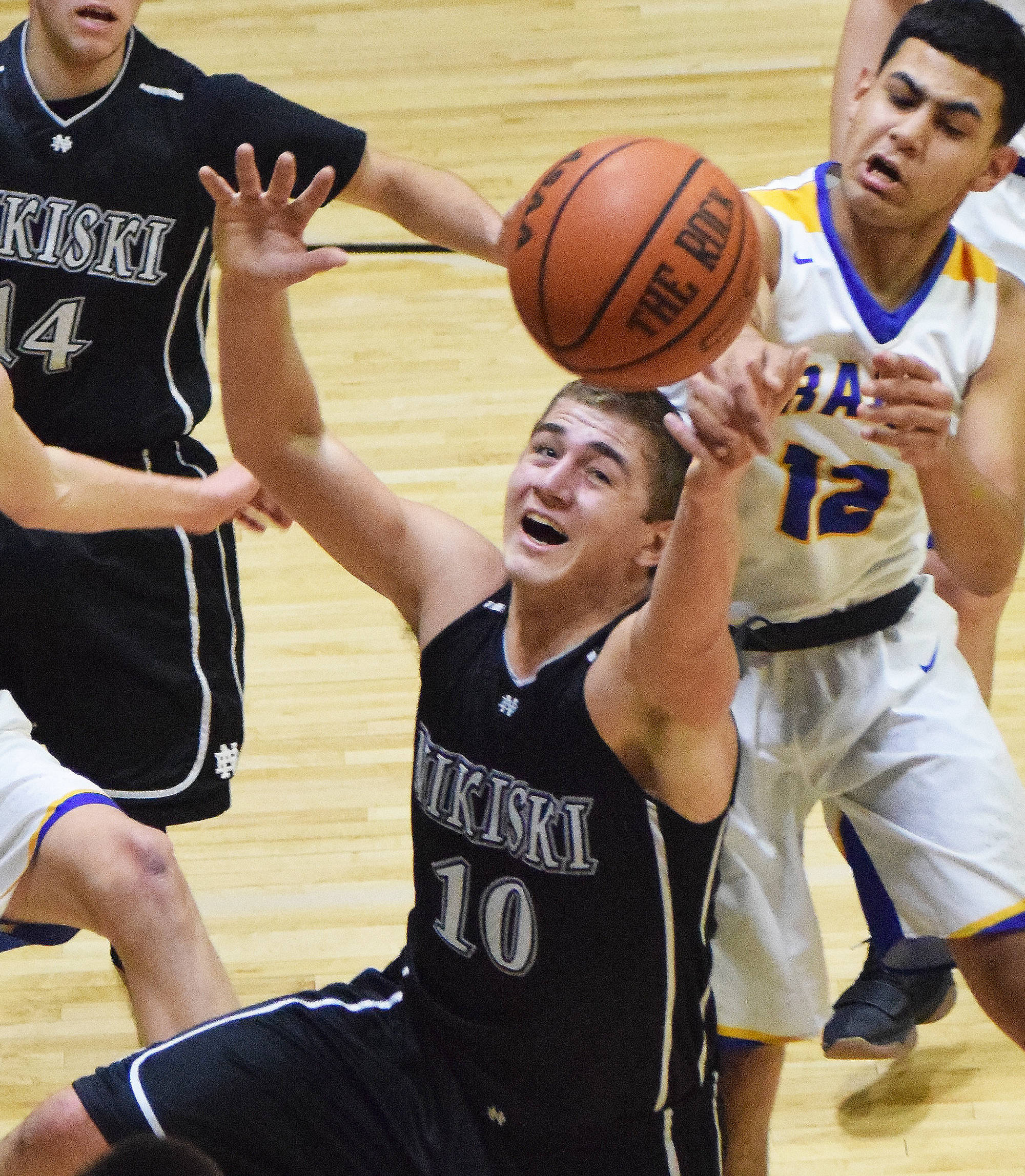 Nikiski senior Ian Johnson (10) corrals a loose ball Friday night against Monroe Catholic at the Rus Hitchcock Nikiski Tip-Off Tournament in Nikiski. (Photo by Joey Klecka/Peninsula Clarion)