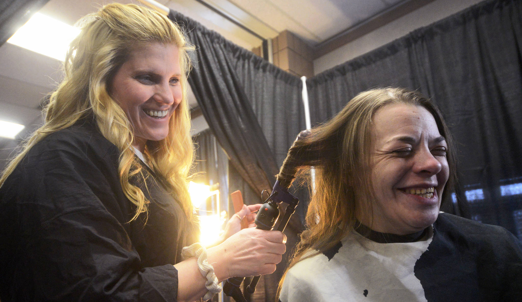 In this 2016 file photo, volunteer hairdresser Joy Conner (left) curls the hair of Alison Alley during Project Homeless Connect, an event at which local individuals and organizations provided information and services to the Kenai Peninsula community members experiencing homelessness. This year’s event will once again provide haircuts, massages, food, and veterinary care on Jan. 24 at the Soldotna Regional Sports Complex. (Photo by Ben Boettger/Peninsula Clarion)