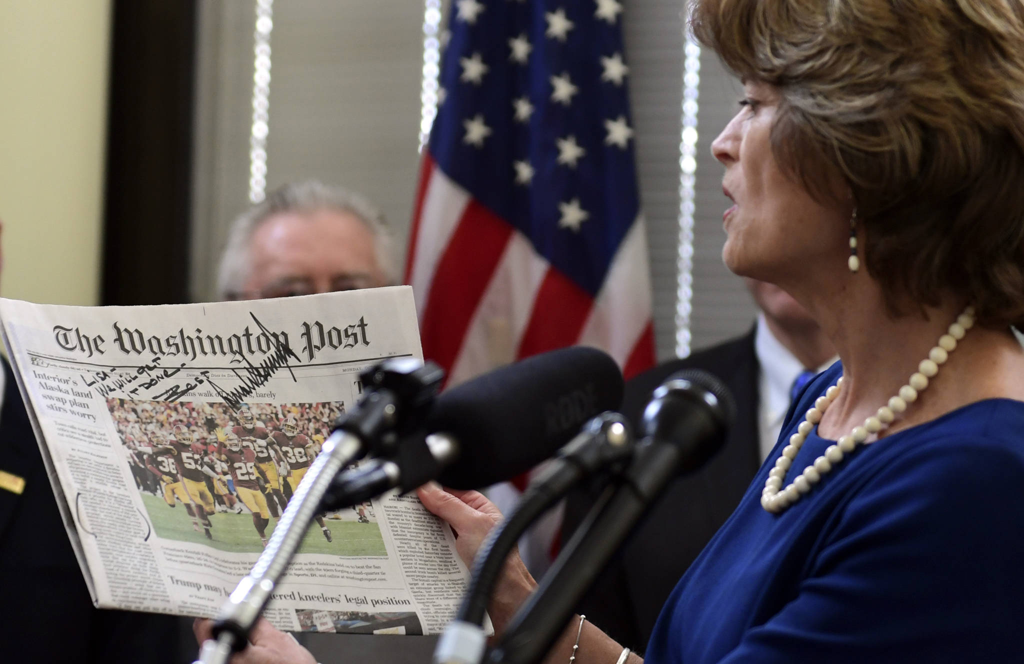 Sen. Lisa Murkowski, R-Alaska, holds up a copy of a news paper with a note from President Donald Trump during an event in her office on Capitol Hill in Washington, Monday, Jan. 22, 2018. Murkowski was joined by other Alaskan officials regarding the Interior Department’s decision to the construction of a road through a national wildlife refuge in Alaska.The road would connect the communities of King Cove and Cold Bay, which has an all-weather airport needed for emergency medical flights. (AP Photo/Susan Walsh)