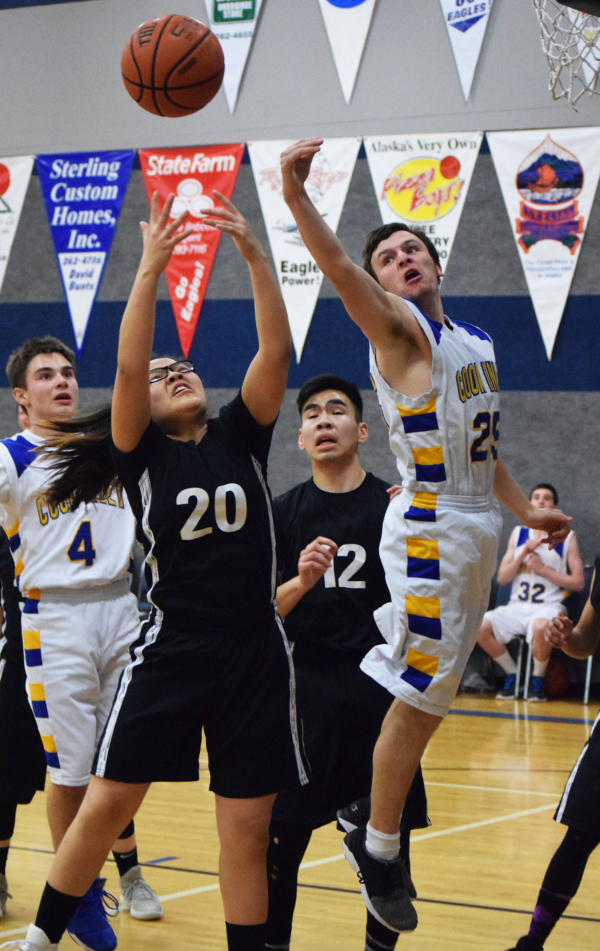 Cook Inlet’s James Anderson contends with Kodiak ESS’s Teanna Amodo (20) for a rebound Thursday night at Cook Inlet Academy in Soldotna. (Photo by Joey Klecka/Peninsula Clarion)