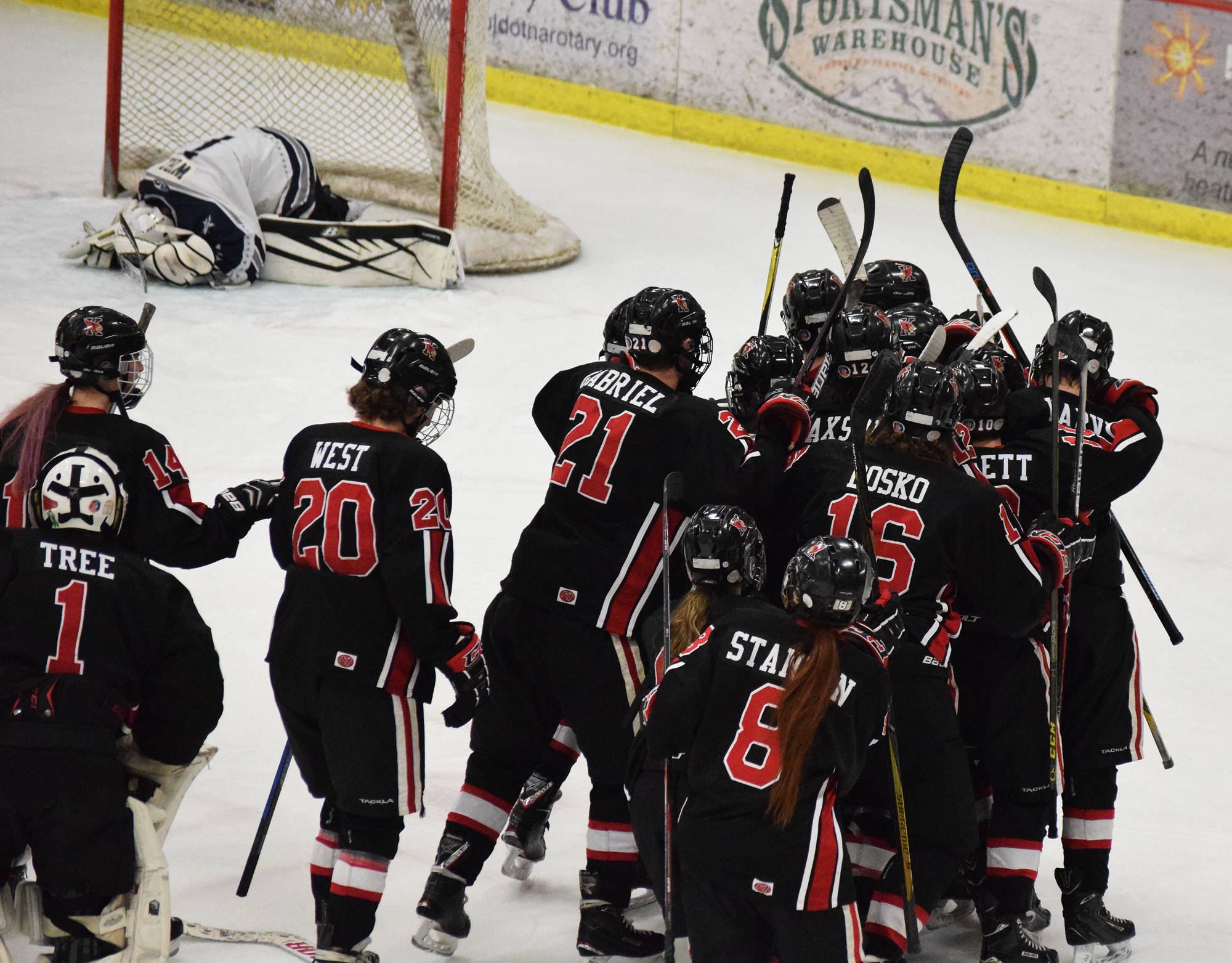 The Kenai Central hockey team celebrates Levi Mese’s overtime goal that gave the Kardinals a 6-5 win over Soldotna on Saturday night at the Soldotna Regional Sports Complex. (Photo by Joey Klecka/Peninsula Clarion)