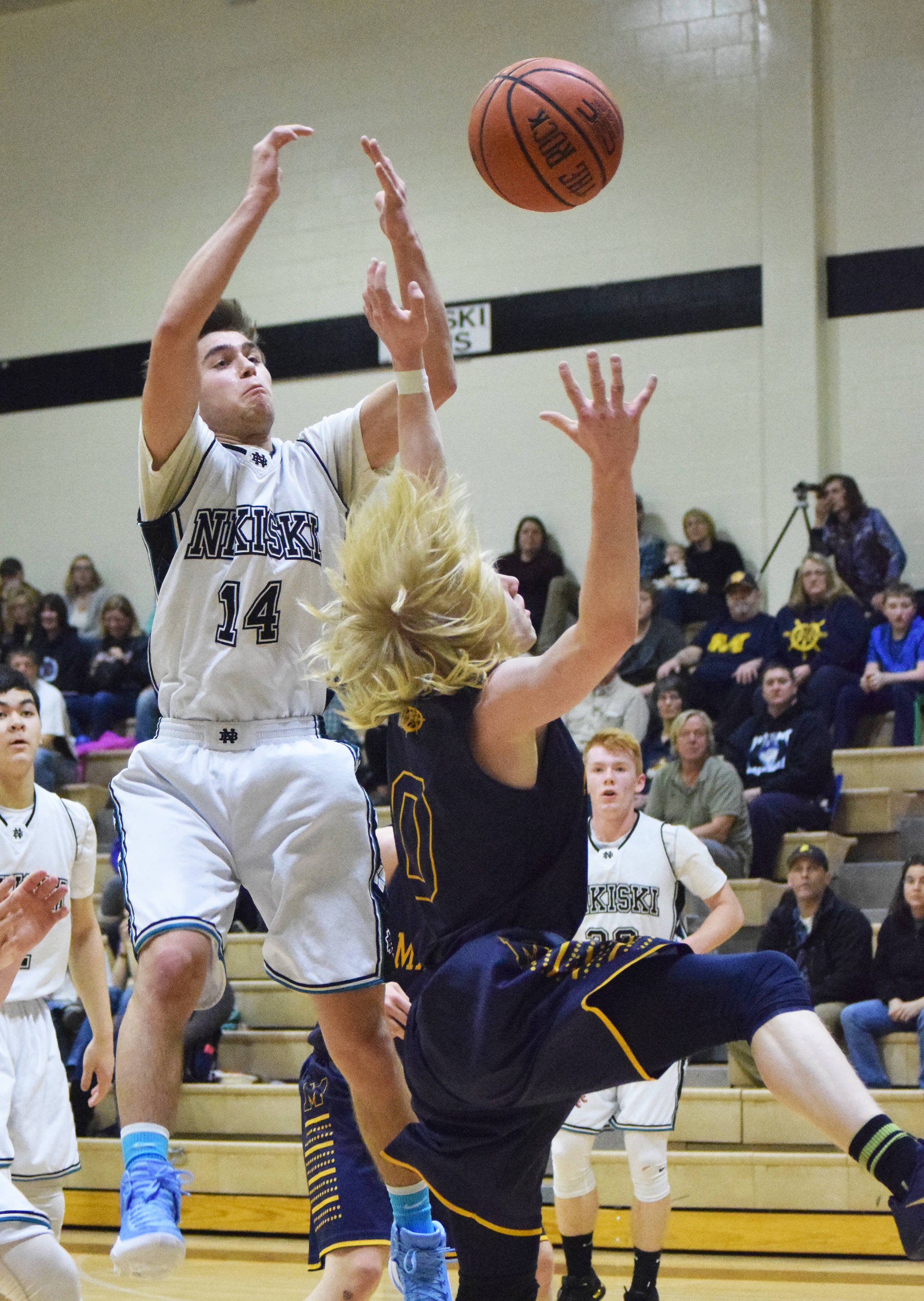 Nikiski’s Garrett Ellis (14) fights for a rebound with Homer’s Charles Rohr (0) Saturday at Nikiski High School. (Photo by Joey Klecka/Peninsula Clarion)