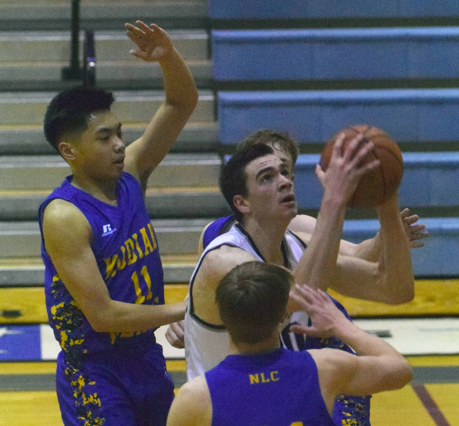 Soldotna’s Sam McElroy goes up for a shot in front of Kodiak’s Sam Glairdo (11) and other defenders Wednesday, Feb. 7, 2018, at Soldotna High School. (Photo by Jeff Helminiak/Peninsula Clarion)