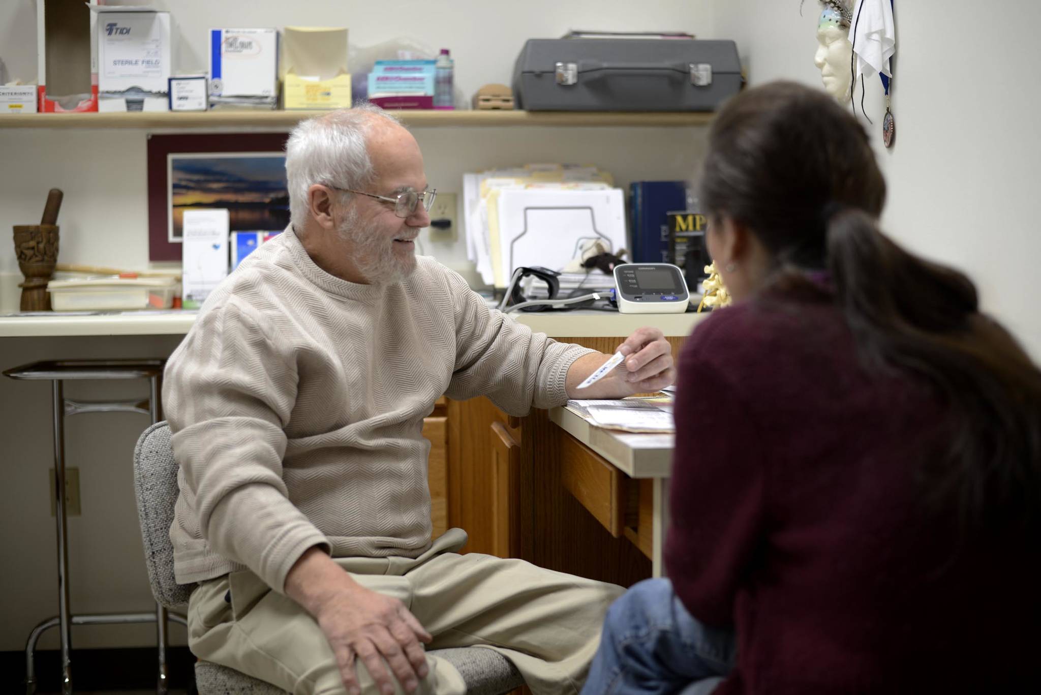 In this Dec. 23, 2015 photo, Dr. Michael Merrick talks to a patient about her addiction as she comes in to get her prescription of Suboxone, a medicine used to treat opioid addictions, in Merrick’s office in Kenai, Alaska. (Clarion file photo)