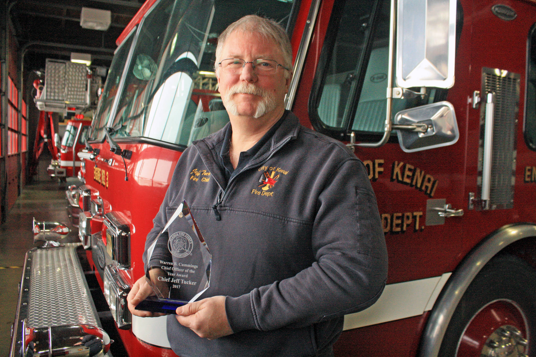 Kenai Fire Chief Jeff Tucker shows off the 2017 Warren B. Cummings Chief Officer of the Year Award at the Kenai Fire Station on Feb. 12. The award recognizes Tucker’s leadership success and contributions to the Alaska fire service. (Photo by Erin Thompson/Peninsula Clarion)