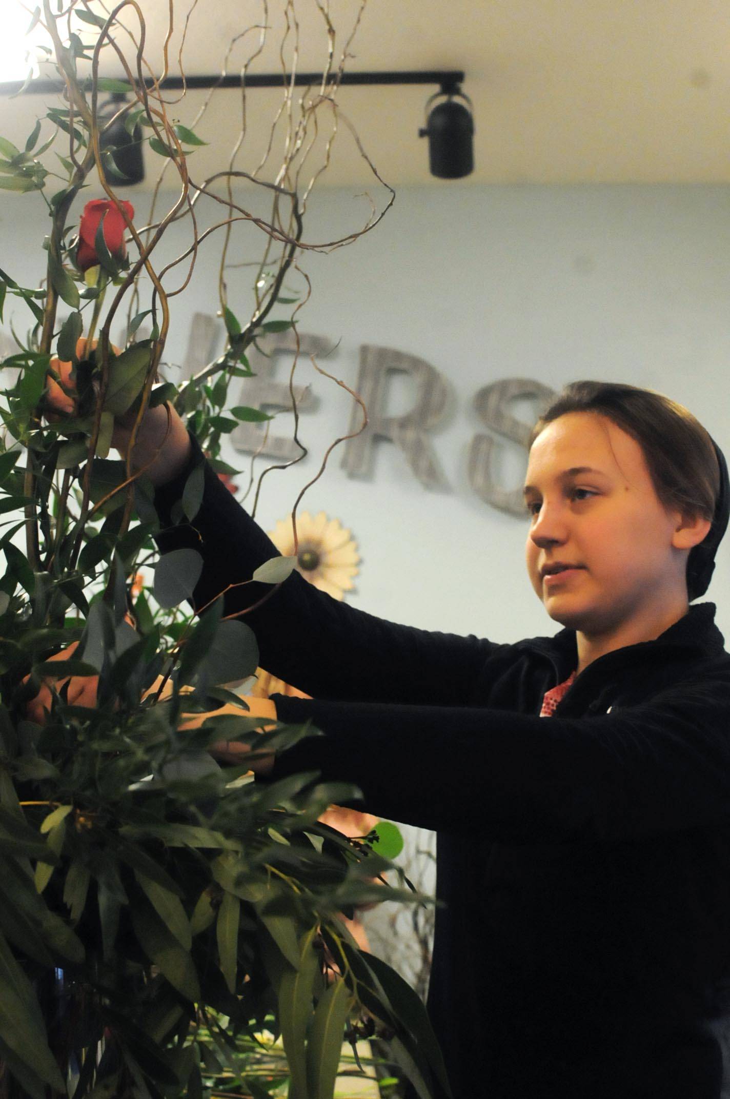 Kate’s Flowers and Gifts florist Kate Mastres arranges a bouquet at the shop on Wednesday, Feb. 14, 2018 in Soldotna, Alaska. Wednesday was a busy day for the shop, with the Valentine’s Day holiday. Mastres said she had been at the shop until 3:30 a.m. Wednesday morning preparing for the next day and arrived at 10 a.m. The shop does custom bouquets as well as some pre-designed ones, she said. (Photo by Elizabeth Earl/Peninsula Clarion)