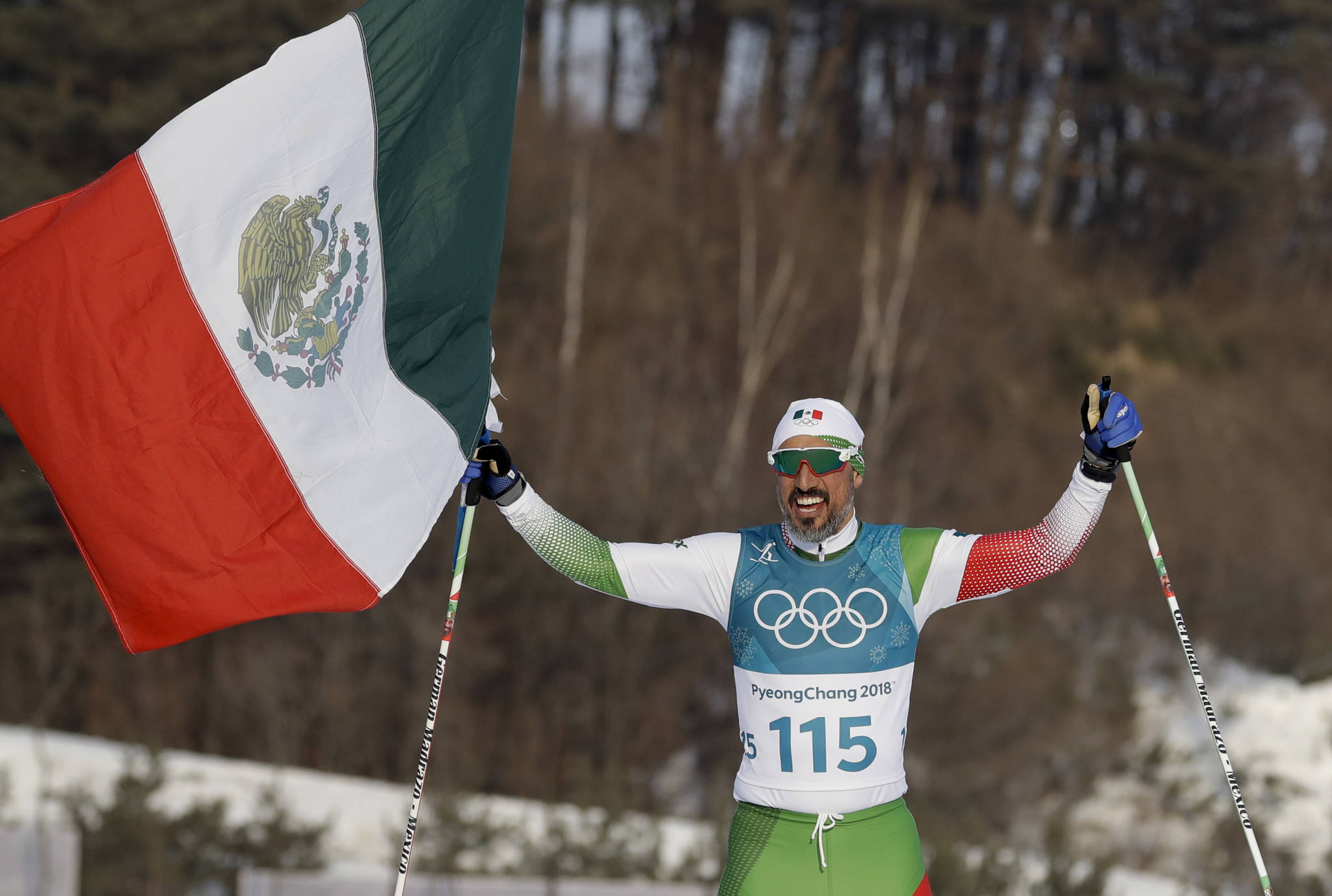 German Madrazo, of Mexico, holds up his flag after finishing last in the men’s 15km freestyle cross-country skiing competition at the 2018 Winter Olympics in Pyeongchang, South Korea, Friday. (AP Photo/Kirsty Wigglesworth)