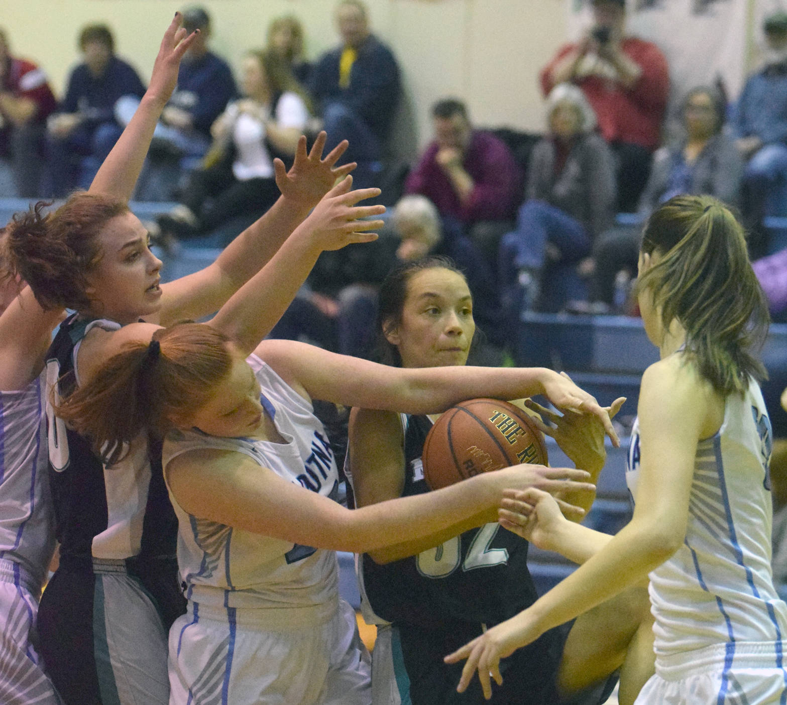 Nikiski’s Bethany Carstens, Soldotna’s Kianna Holland, Nikiski’s Rylee Jackson and Soldotna’s Danica Schmidt battle for a rebound Tuesday, Feb. 20, 2018, at Soldotna High School. (Photo by Jeff Helminiak/Peninsula Clarion)