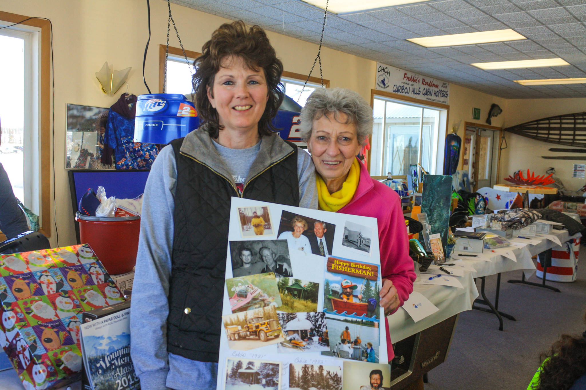 Nancy Myers, left, and her mother Betty Harris share family photos memorializing family patriarch Jim Harris, who died of cancer in 2017 on Saturday, Feb. 24, 2018 near Ninilchik, Alaska. Jim Harris was honored at this year’s WOW event. (Photo by Erin Thompson/Peninsula Clarion)