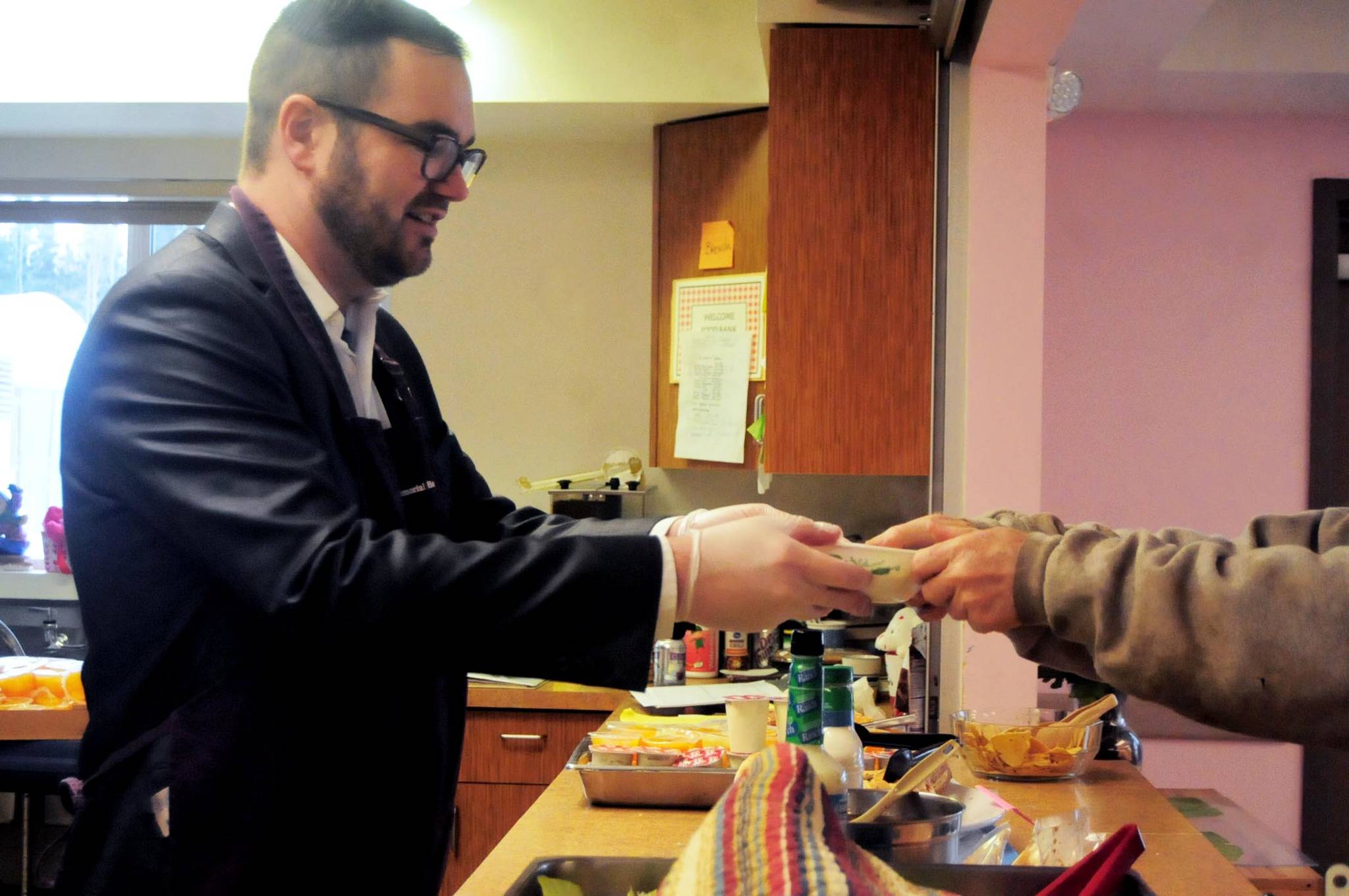 John Quick, chief of staff to Kenai Peninsula Borough Mayor Charlie Pierce, serves a bowl of soup to a diner at the Kenai Peninsula Food Bank’s Fireweed Diner on Friday, March 2, 2018 near Soldotna, Alaska. Kenai Peninsula Borough and Kenai Peninsula Borough School District employees volunteer at the food bank every other Friday and have been doing so for more than a decade. (Photo by Elizabeth Earl/Peninsula Clarion)