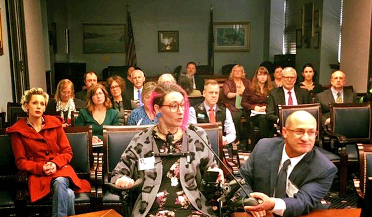 Kenai resident Maggie Winston (center) and Governor’s Council on Disabilities and Special Education Executive Director Patrick Reinhart (right) testify in favor of Senate Bill 174 to the Senate Health and Social Services Committe in Juneau, Alaska. Senate Bill 174 would add language to state administrative code giving people with disabilities a more active role in determining their services and care. (Photo courtesy Maggie Winston)