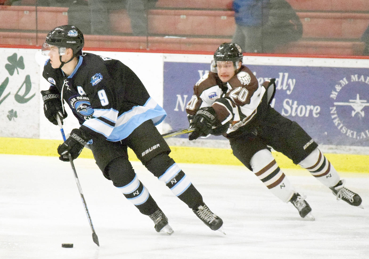 Kenai River forward Tyler Miknich (right) tries to get a stick on Coulee Region defenseman Marshal Plunkett on Jan. 12 at the Soldotna Regional Sports Complex. (Photo by Joey Klecka/Peninsula Clarion)