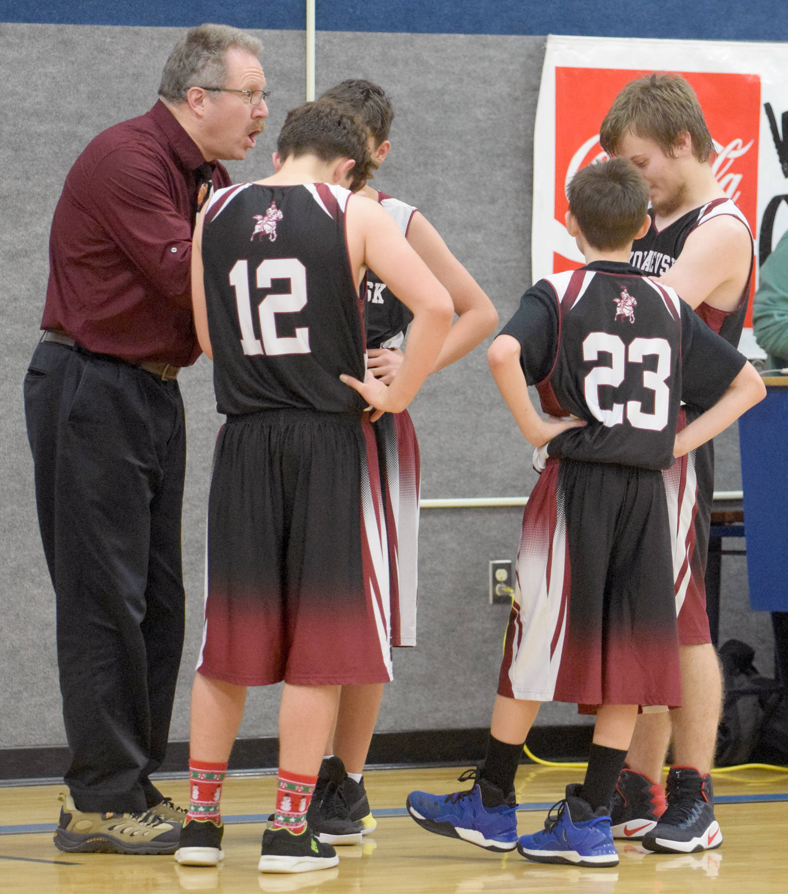 Veteran Nikolaevsk boys coach Steve Klaich directs his team in the Cook Inlet Classic at Cook Inlet Academy in Soldotna in December 2017. Klaich will lead his team at the Class 3A state tournament today. (Photo by Jeff Helminiak/Peninsula Clarion)