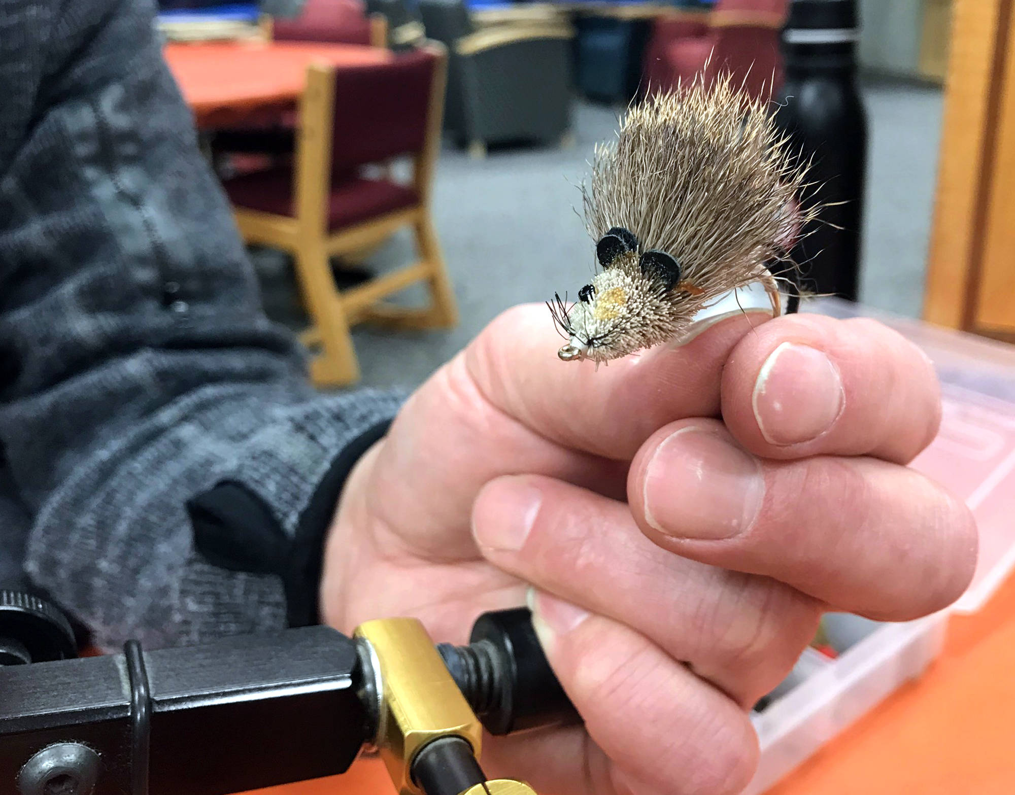 LEFT: Dave Atcheson displays a fly that resembles a small mouse, which would be useful in western Alaska where the small animals are a major food source for local fish. (Photo by Kat Sorensen/Peninsula Clarion)