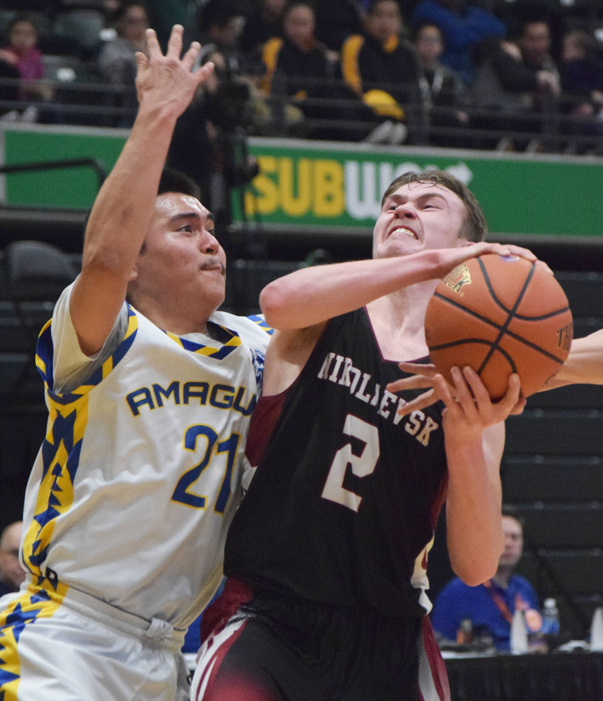 Nikolaevsk’s Kalenik Molodih drives to the rim against Nunamiut’s Dyrell Lincoln Thursday in a Class 1A state tournament quarterfinal at the Alaska Airlines Center in Anchorage. (Photo by Joey Klecka/Peninsula Clarion)