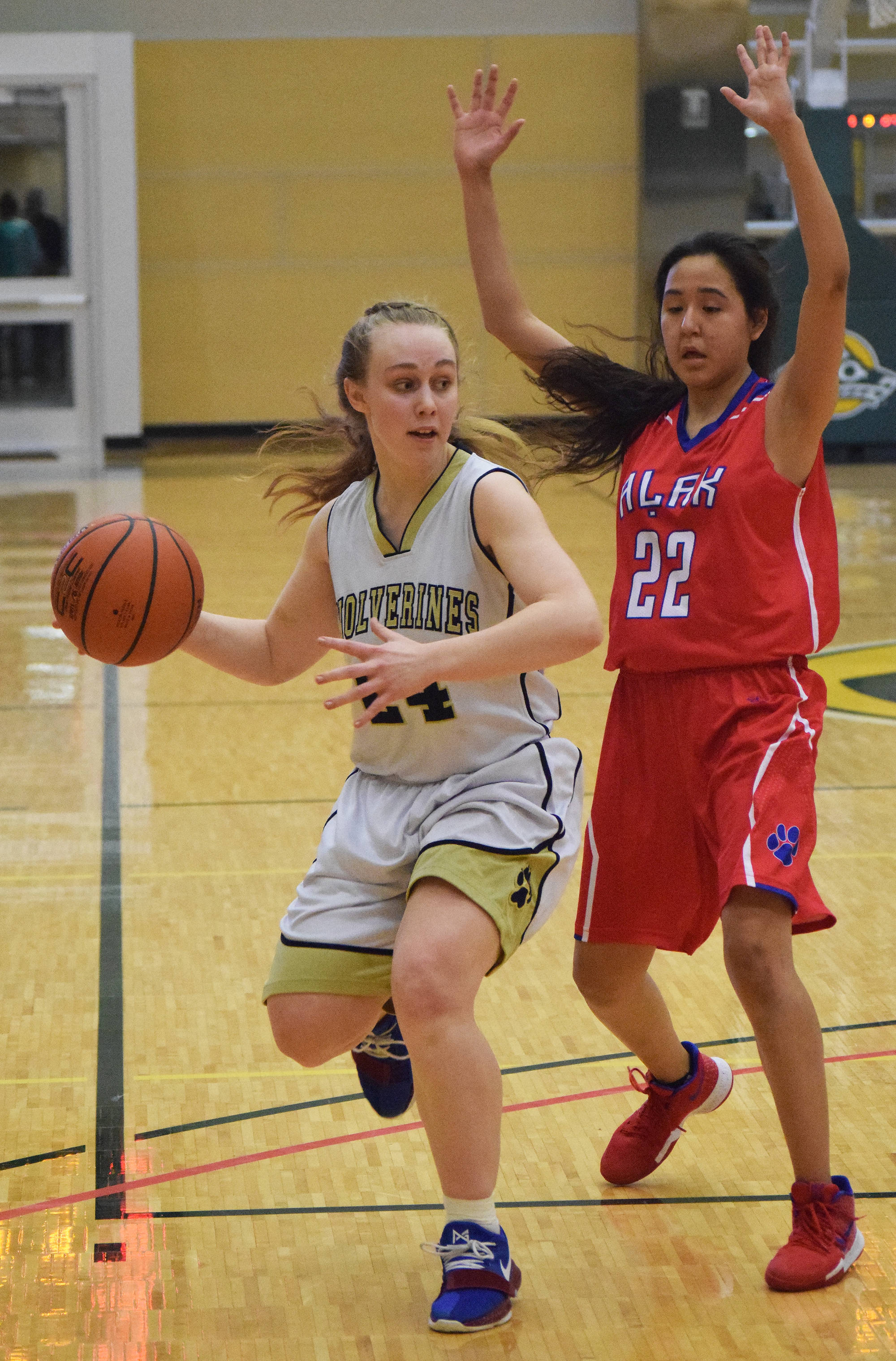 Ninilchik’s Isabella Koch (left) looks for a teammate with Alak’s Jenysa Ahmaogak defending her Thursday evening at the Class 1A state tournament at the Alaska Airlines Center in Anchorage. (Photo by Joey Klecka/Peninsula Clarion)