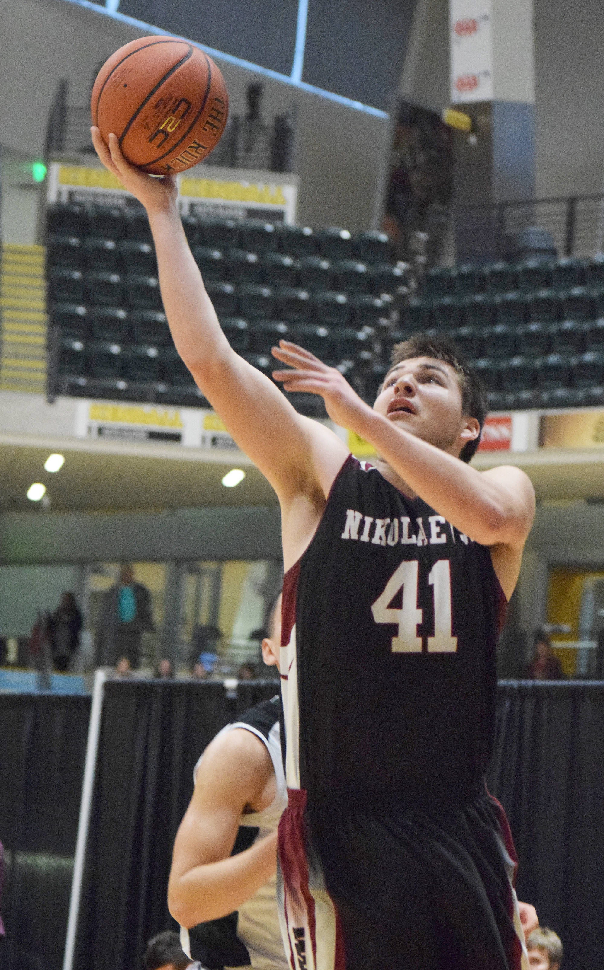 Nikolaevsk junior Michael Trail puts up a layup Friday in a Class 1A state tournament fourth-place semifinal contest against Shishmaref at the Alaska Airlines Center. (Photo by Joey Klecka/Peninsula Clarion)