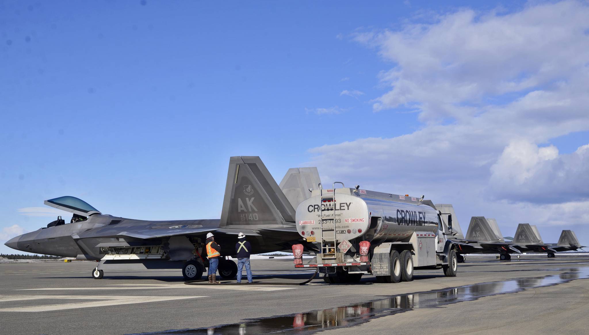 A Crowley tanker truck fuels the eight U.S. Air Force F-22 “Raptor” fighter jets that landed at the Kenai Municipal Airport on Monday, March 19, 2018 in Kenai. Weather conditions stopped the fighters from landing at Joint Base Elmendorf-Richardson in Anchorage, their home field. Four of the F-22s belong to the 90th Fighter Squadron and four to the 525th Fighter Squadron, which were on separate training flights before landing in Kenai, said Major Stephen Montgomery, a pilot with the 90th. The fighters took off for Anchorage Monday afternoon. F-22s from Elmendorf have been occasionally using Kenai as an alternate landing site since October 2016, when a pair of the fighters landed there to assess the possibility. (Photo by Ben Boettger/Peninsula Clarion)