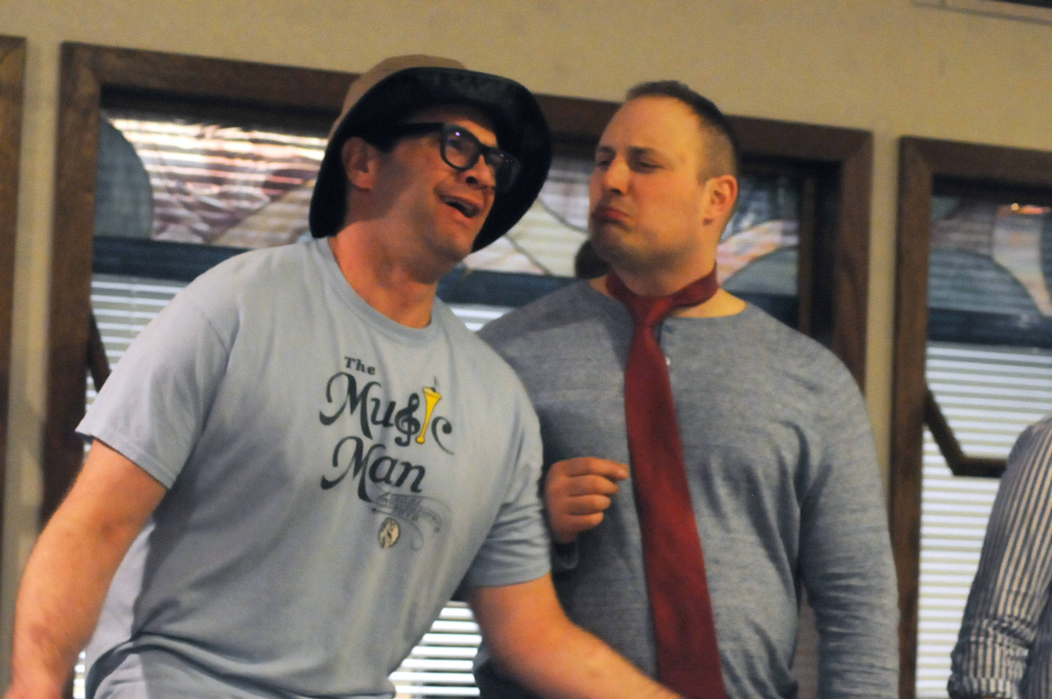 Chris Pepper (left) and Tyler Payment (right) play out a scene during a rehearsal for Triumvirate Theatre’s production of “Forrest Guppy” on Tuesday, March 20, 2018 in Soldotna, Alaska. Pepper plays Forrest Guppy, a parody of the main character from the classic film “Forrest Gump,” in the comedy parody of the film, while Payment reprises his role as President Donald Trump from the theater’s fall 2016 production of “Lame Ducks and Dark Horses.” The theater troupe last put on the dinner theater production in 2010. (Photo by Elizabeth Earl/Peninsula Clarion)