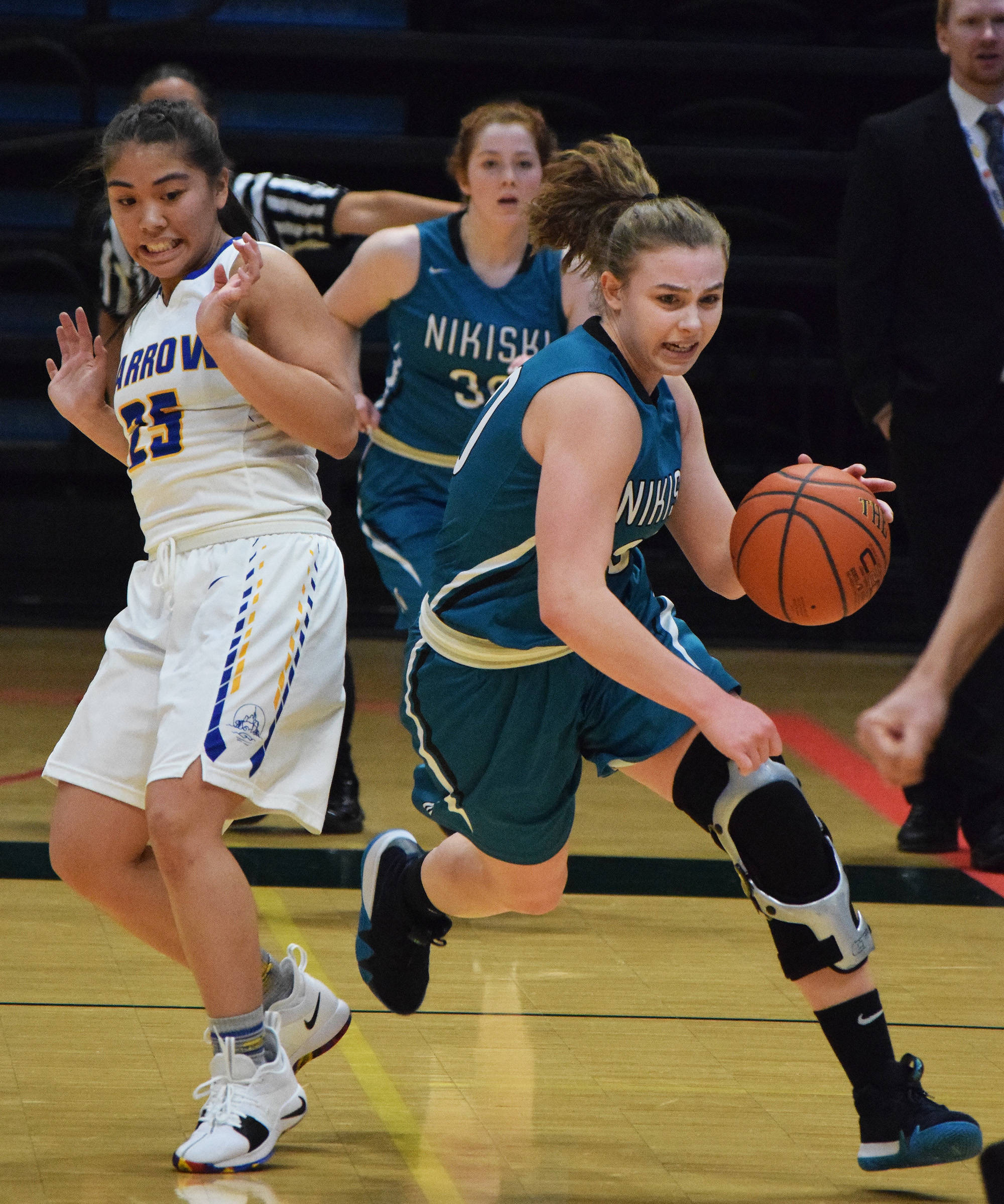 Nikiski’s Bethany Carstens (right) dodges Barrow defender Jordan Ahgeak in the second half of a quarterfinal contest Thursday evening at the Class 3A state tournament at the Alaska Airlines Center. (Photo by Joey Klecka/Peninsula Clarion)
