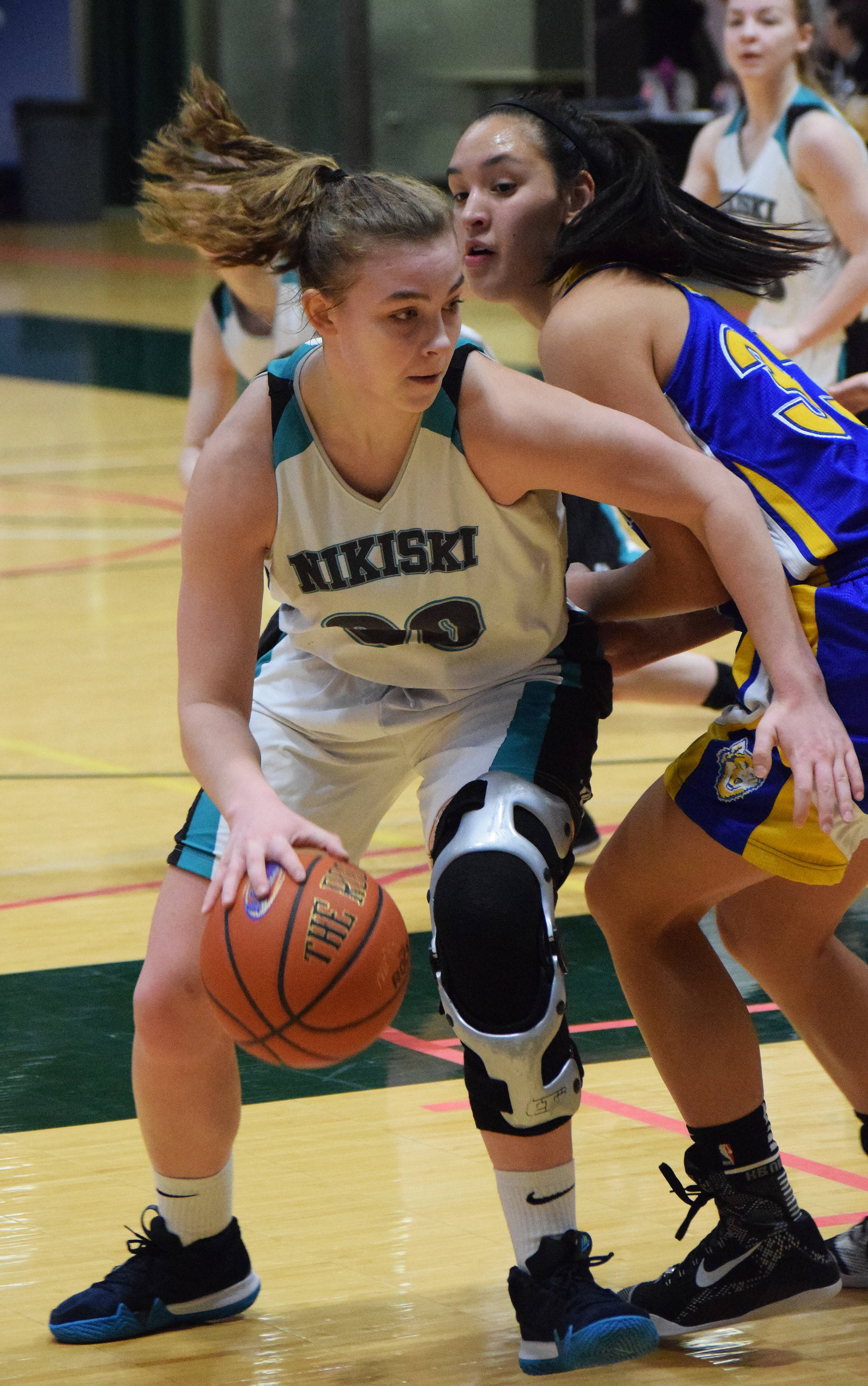 Nikiski’s Bethany Carstens makes a move around Kotzebue’s Alanna Conwell Friday at the Class 3A state tournament at the Alaska Airlines Center. (Photo by Joey Klecka/Peninsula Clarion)