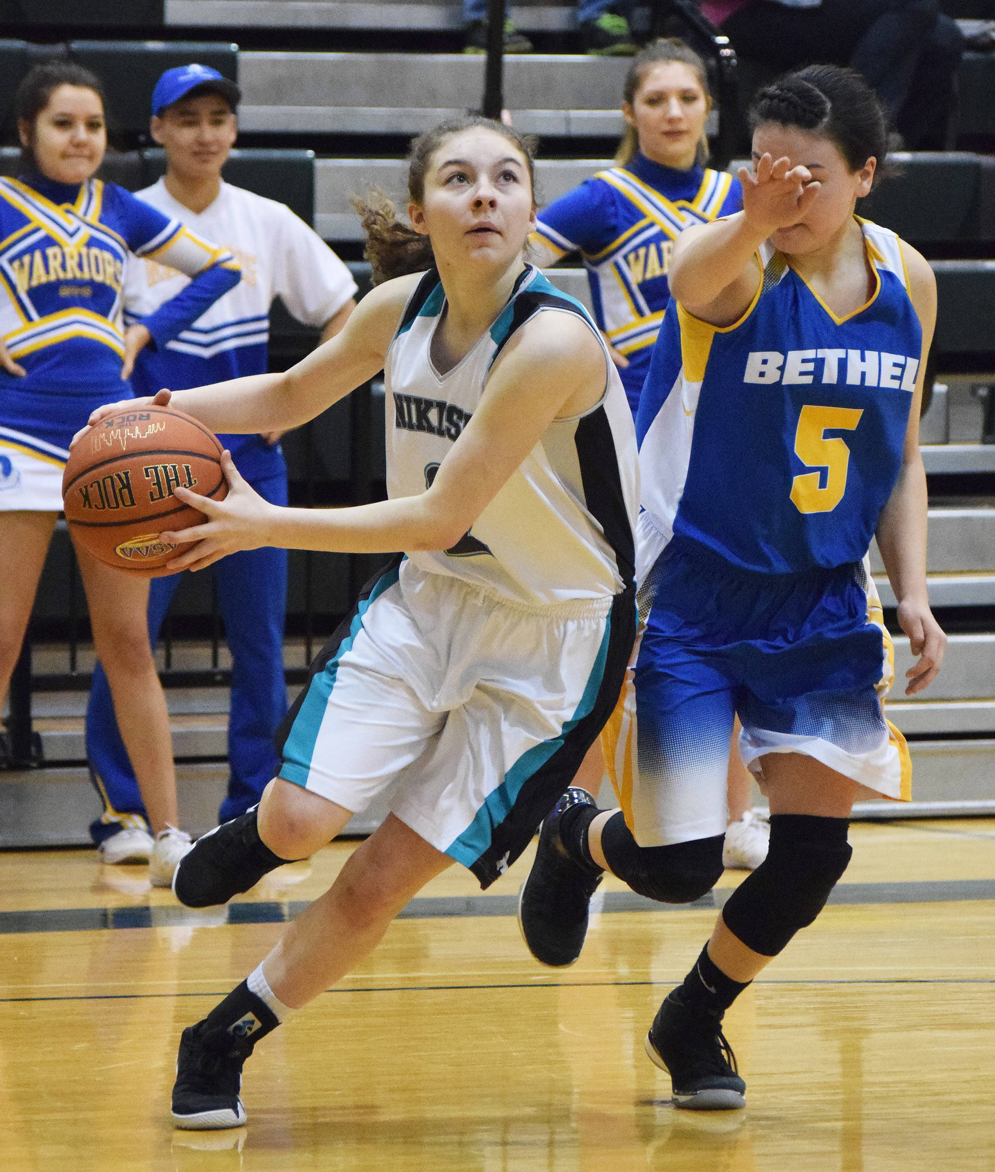 Nikiski’s America Jeffreys (left) drives the baseline against Bethel’s Dorothy Bukowski Saturday in the Class 3A girls state tournament fourth-place game at the UAA Wells Fargo Complex in Anchorage. (Photo by Joey Klecka/Peninsula Clarion)