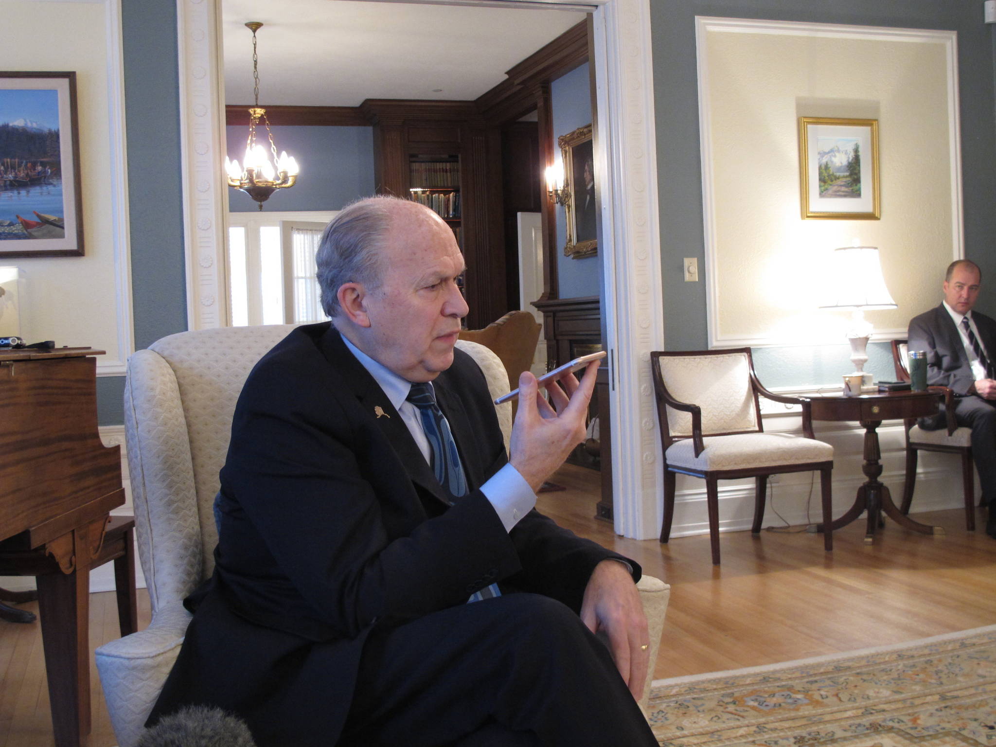 In this March 13 photo, Gov. Bill Walker speaks by phone to a reporter not physically present for a media availability at the governor’s mansion in Juneau. (AP Photo/Becky Bohrer)