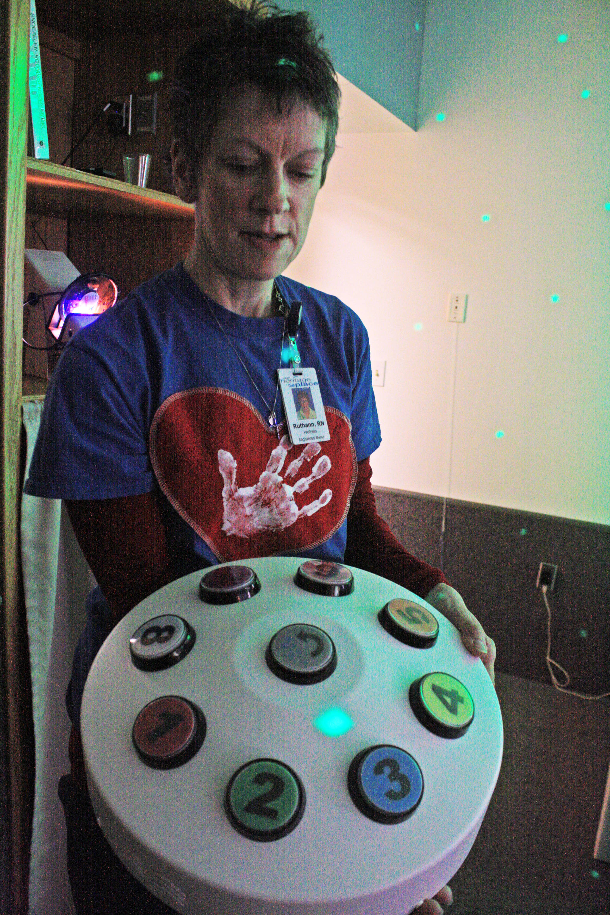 Ruthann Truesdell, Heritage Place staff training coordinator, discusses an interface that residents can use to change the lighting in the home’s new Snoezelen room, which provides an interactive relaxation experience for residents, on March 23 in Soldotna. (Photo by Erin Thompson/Peninsula Clarion)