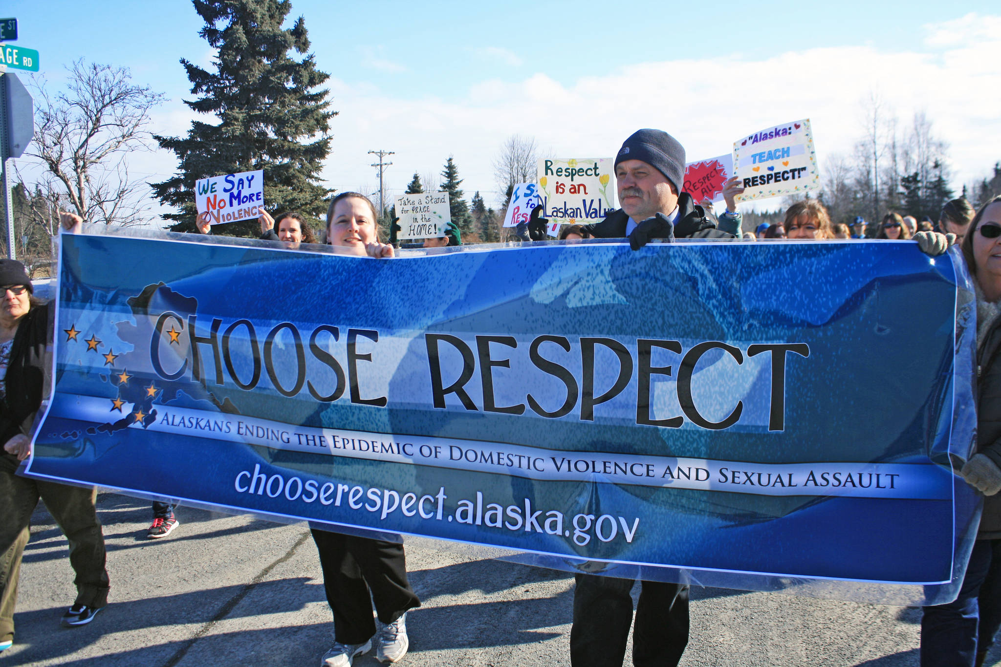 Marchers hold a banner promoting respect during the Alaskans Choose Respect Awareness Event, hosted by the LeeShore Center on March 28. (Photo by Erin Thompson/Peninsula Clarion)