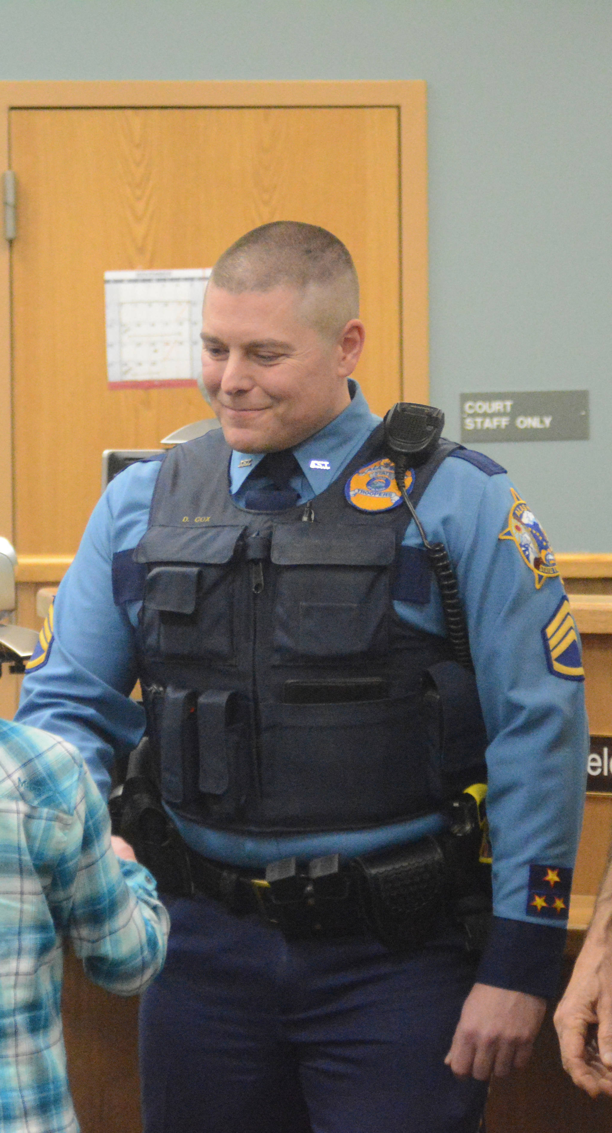 Sgt. Daniel Cox congratulates a Kenai Peninsula Youth Court attorney at swearing-in ceremonies at the Homer Courthouse in December 2016. (Photo by Michael Armstrong, Homer News)