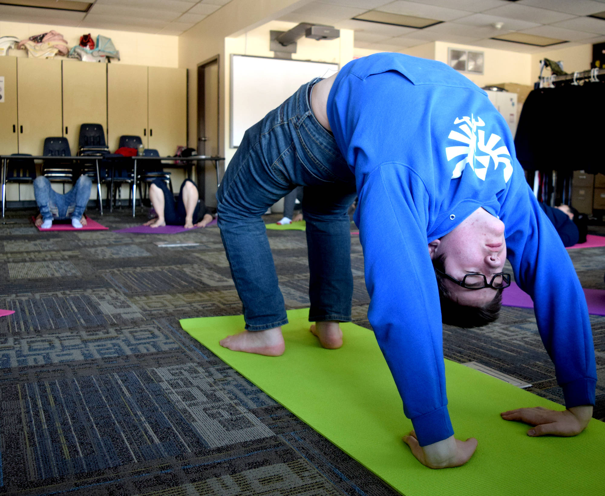 Soldotna High School student Jaron Swanson does bridge pose Friday while in a yoga class offered during the Focus on Learning period at the end of each school day. (Photo by Kat Sorensen/Peninsula Clarion)