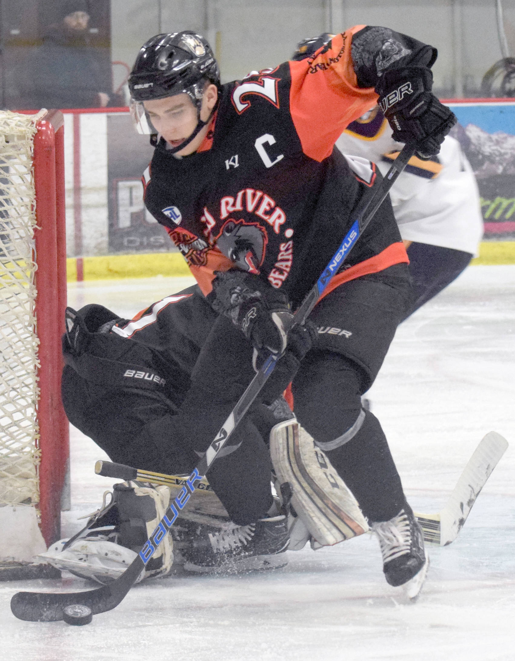 Kenai River Brown Bears defenseman Preston Weeks, of Soldotna, clears the puck from near the goal March 16, 2018, at the Soldotna Regional Sports Complex in a game against the Springfield (Illinois) Jr. Blues. (Photo by Jeff Helminiak/Peninsula Clarion)