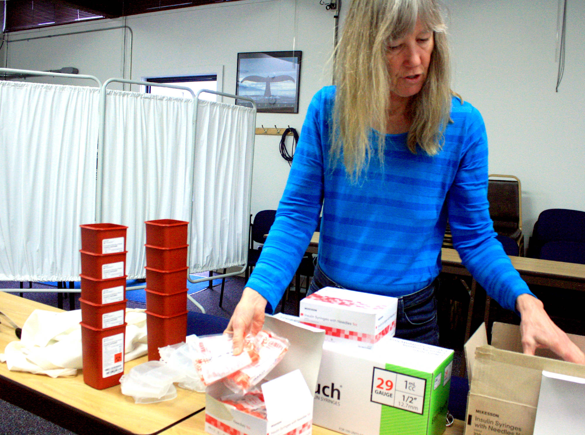 Homer Needle Exchange volunteer Sharon Whytal demonstrates a variety of items offered to IV drug users through the exchange program in Homer last month. (Photo by Erin Thompson/Peninsula Clarion)