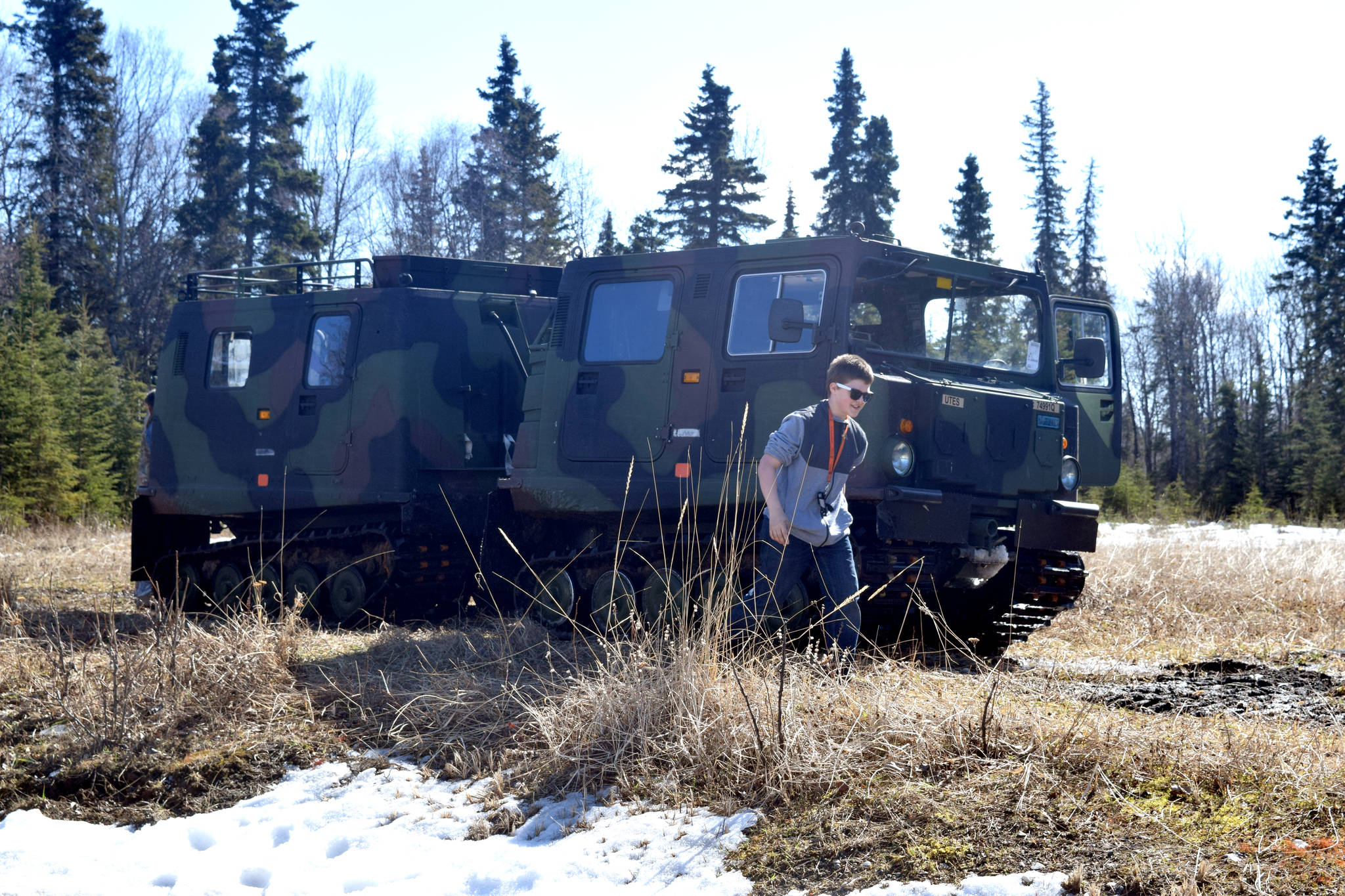 A guest at Saturday’s National Guard Demo Day at the Kenai Armory in Kenai walks from a small until support vehicle, which is used by the Guard to traverse all different types of terrain. (Photo by Kat Sorensen/Peninsula Clarion)