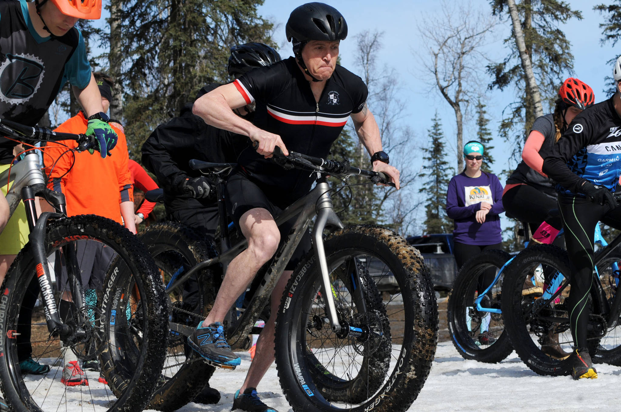 Mike Crawford of Kenai launches his fatbike on the Wolverine Trail at the start of the 2018 Choose Your Weapon race at Tsalteshi Trails on Sunday, April 15, 2018 in Soldotna, Alaska. Racers completed two 5-kilometer laps around the lower trails by running, biking or skiing, with the option of switching between laps for extra points. Most of the trails had some snow with patches of wet mud sprinkled throughout as spring temperatures begin to dominate the central Kenai Peninsula. (Photo by Elizabeth Earl/Peninsula Clarion)
