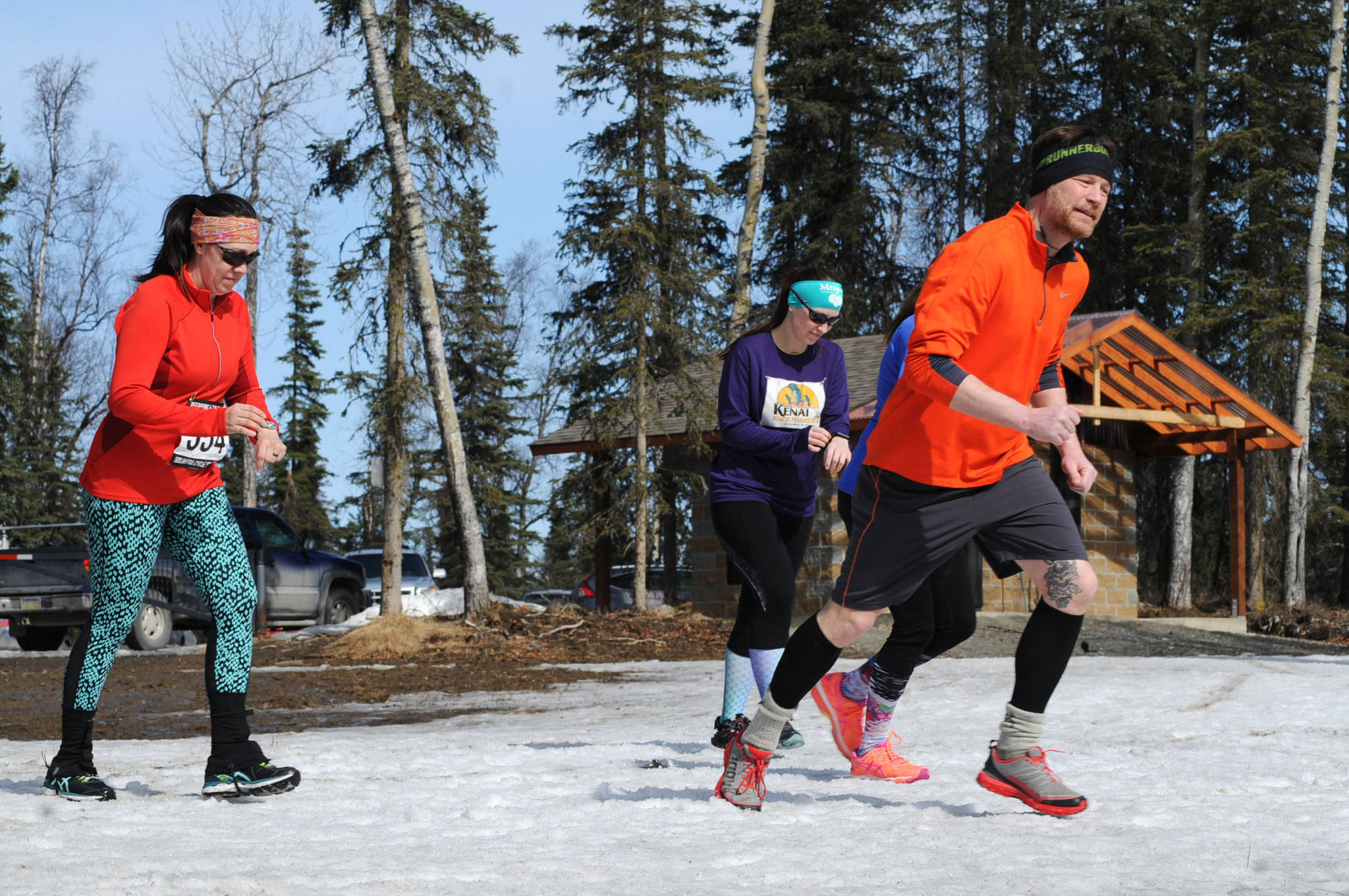 Runners take off on the Wolverine Trail at the start of the 2018 Choose Your Weapon race at Tsalteshi Trails on Sunday, April 15, 2018 in Soldotna, Alaska. Racers completed two 5-kilometer laps around the lower trails by running, biking or skiing, with the option of switching between laps for extra points. Most of the trails had some snow with patches of wet mud sprinkled throughout as spring temperatures begin to dominate the central Kenai Peninsula. (Photo by Elizabeth Earl/Peninsula Clarion)