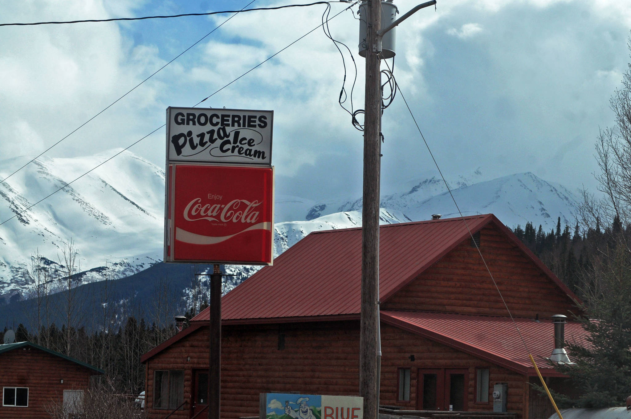 Snow-covered mountains provide a backdrop for Cooper Landing in this April 11 photo. The Sterling Highway, the main corridor to and from the Kenai Peninsula, winds through the little community of Cooper Landing, often bringing dense traffic and car accidents with it, particularly in the summer. (Photo by Elizabeth Earl/Peninsula Clarion)