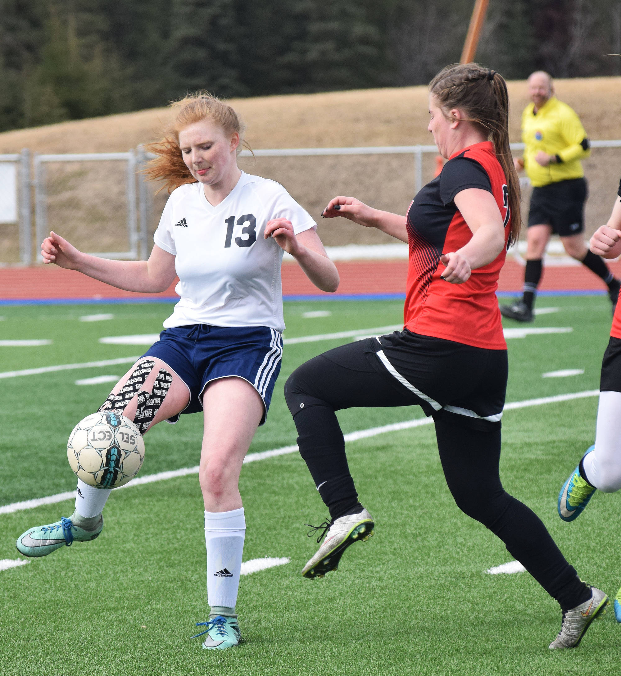 Soldotna’s Kianna Holland works to keep the ball from Kenai Central’s Olivia Brewer Tuesday at Justin Maile Field in Soldotna. (Photo by Joey Klecka/Peninsula Clarion)