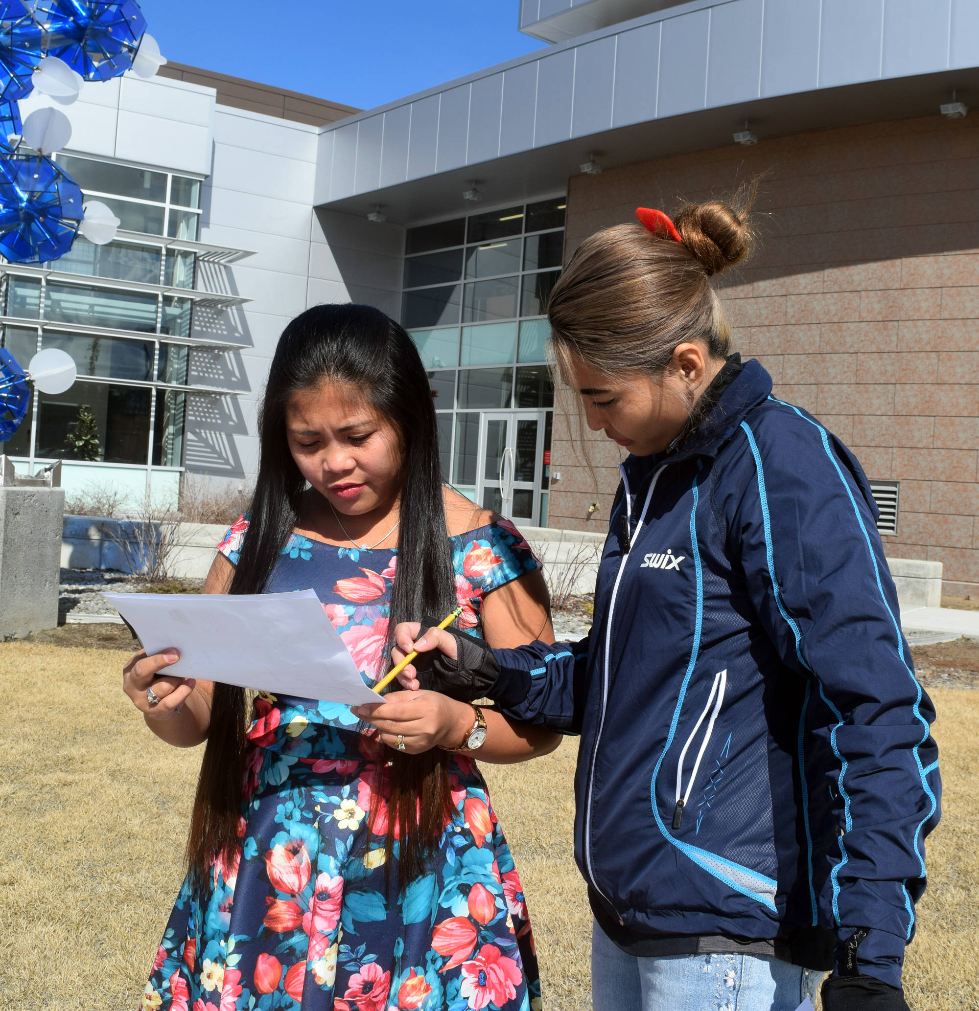 ABOVE: Mirasol O’Fallon, right, and Analyn Elliott participate in a scavenger hunt across the Kenai Peninsula College campus Thursday during their weekly English as a second language conversation group. (Photo by Kat Sorensen/Peninsula Clarion)
