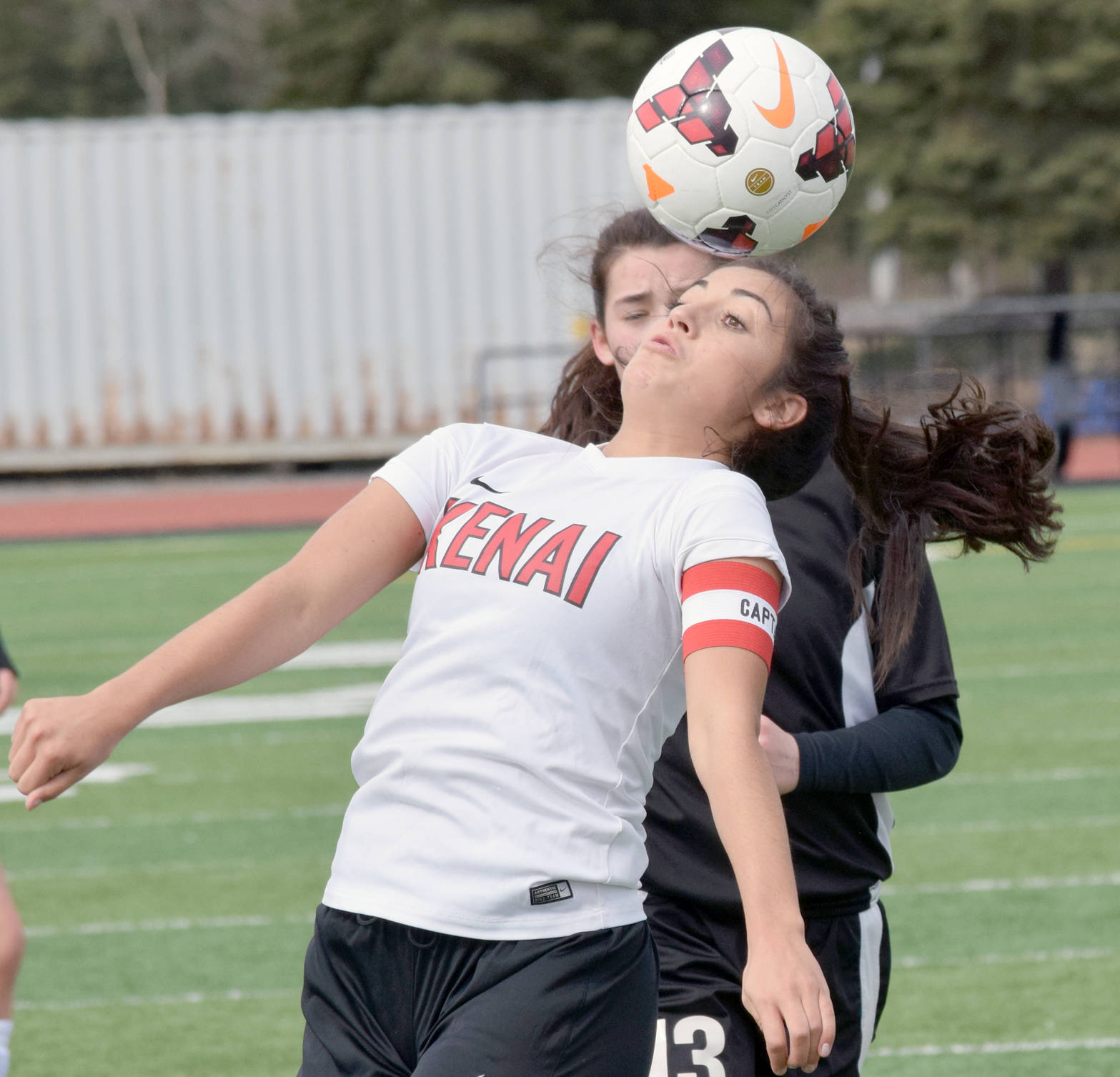 Kenai Central’s Brenna Eubank controls the ball in front of Nikiski’s Tika Zimmerman on Monday, April 23, 2018, at Kenai Central High School. (Photo by Jeff Helminiak/Peninsula Clarion)