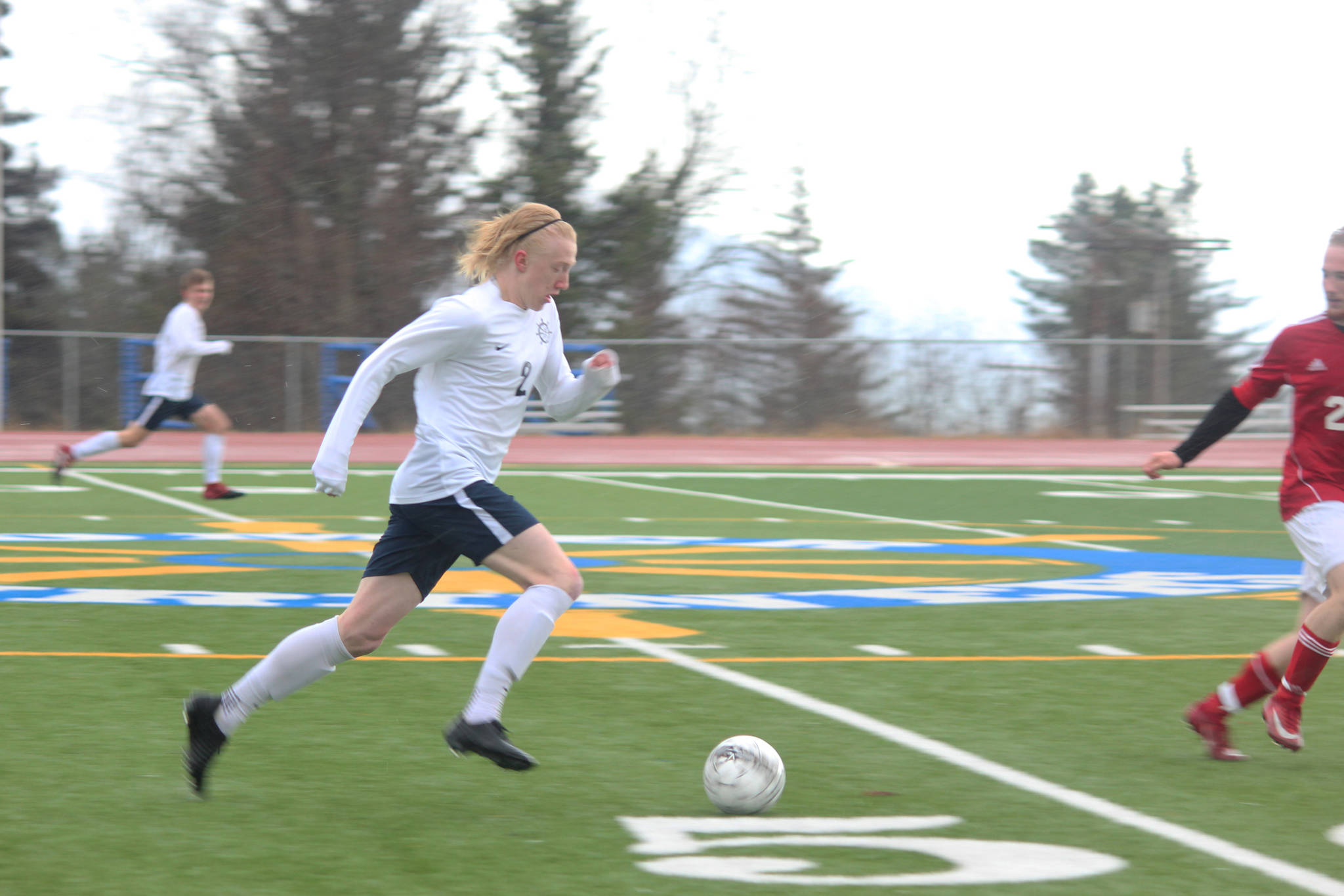 Homer senior Charles Rohr charges down the field with the ball during Homer High School’s game against Kenai Central High School on Tuesday, April 24, 2018 in Homer, Alaska. The Kardinals beat the Mariners 6-2. (Photo by Megan Pacer/Homer News)