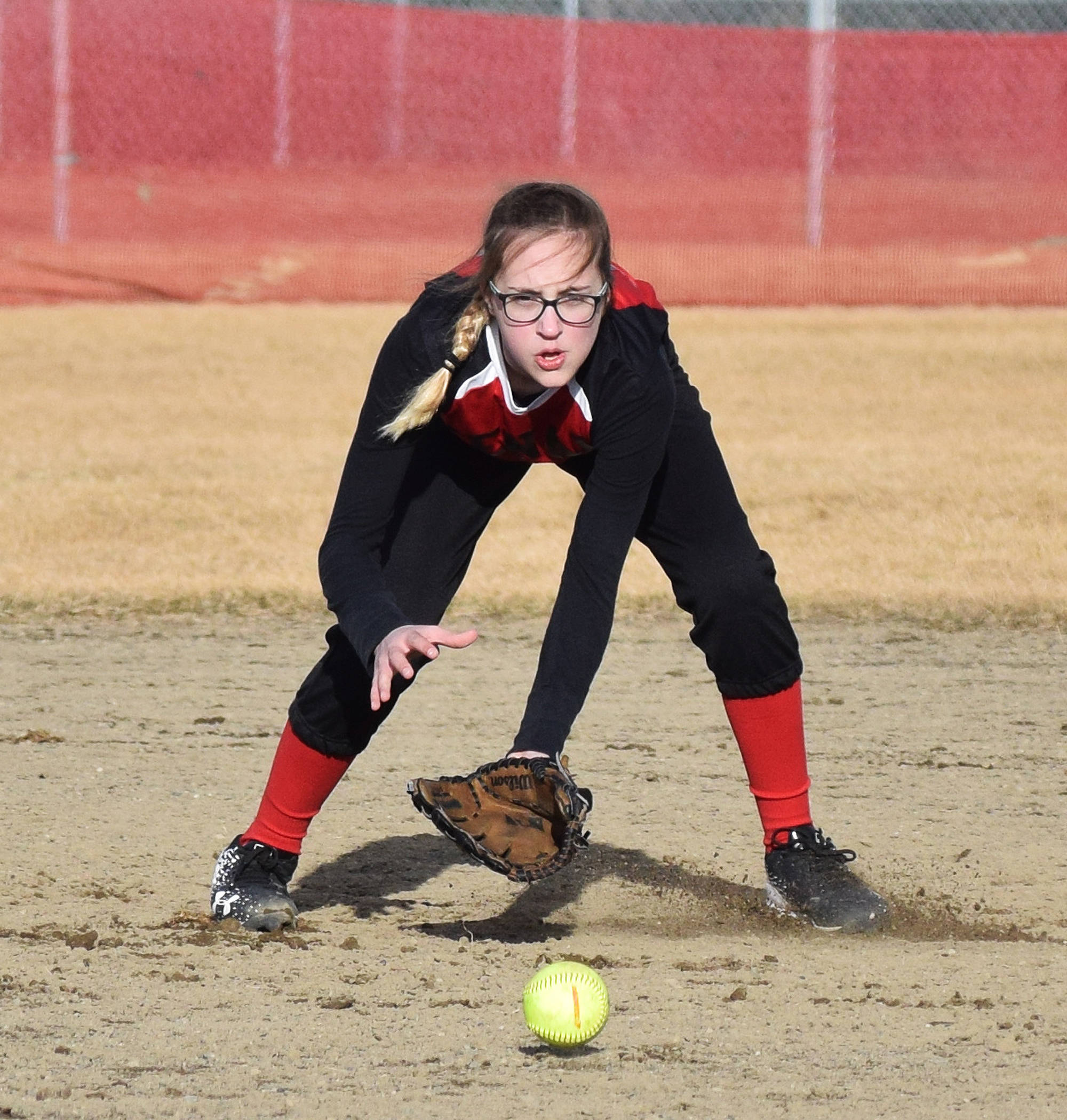 Kenai Central’s Zaharah Wilshusen fields a grounder from a Kodiak batter Thursday evening at Steve Shearer Memorial Ball Park in Kenai. (Photo by Joey Klecka/Peninsula Clarion)