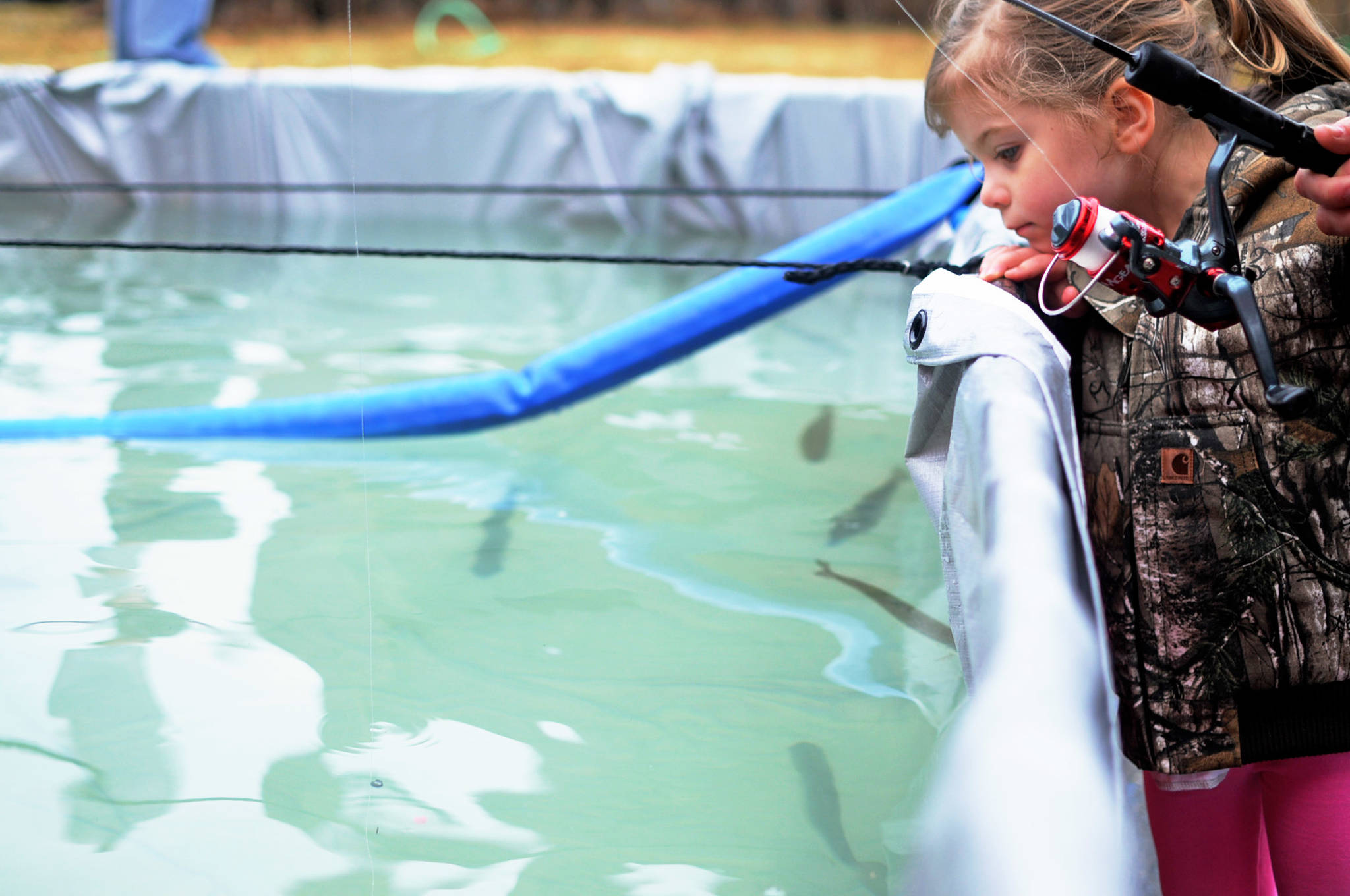 Harper Leck, 3, watches as her line and weight sink into the water at an Alaska Department of Fish and Game-stocked fish pond at the annual Sports and Rec Trade Show at the Soldotna Regional Sports Complex on Sunday, April 29, 2018 in Soldotna, Alaska. (Photo by Elizabeth Earl/Peninsula Clarion)